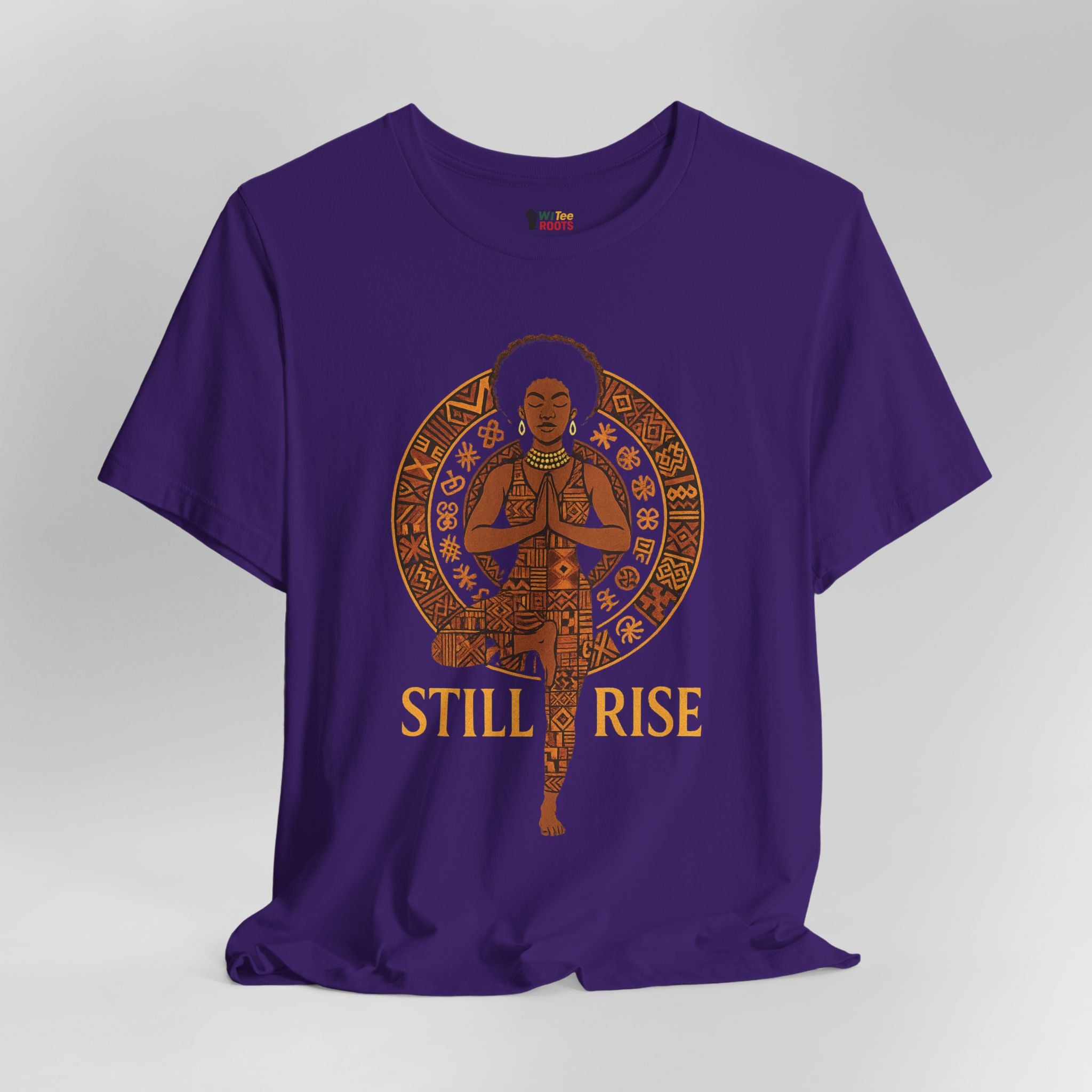 Purple t-shirt with a graphic of a person in a meditative pose and 'STILL RISE' text on a grey background