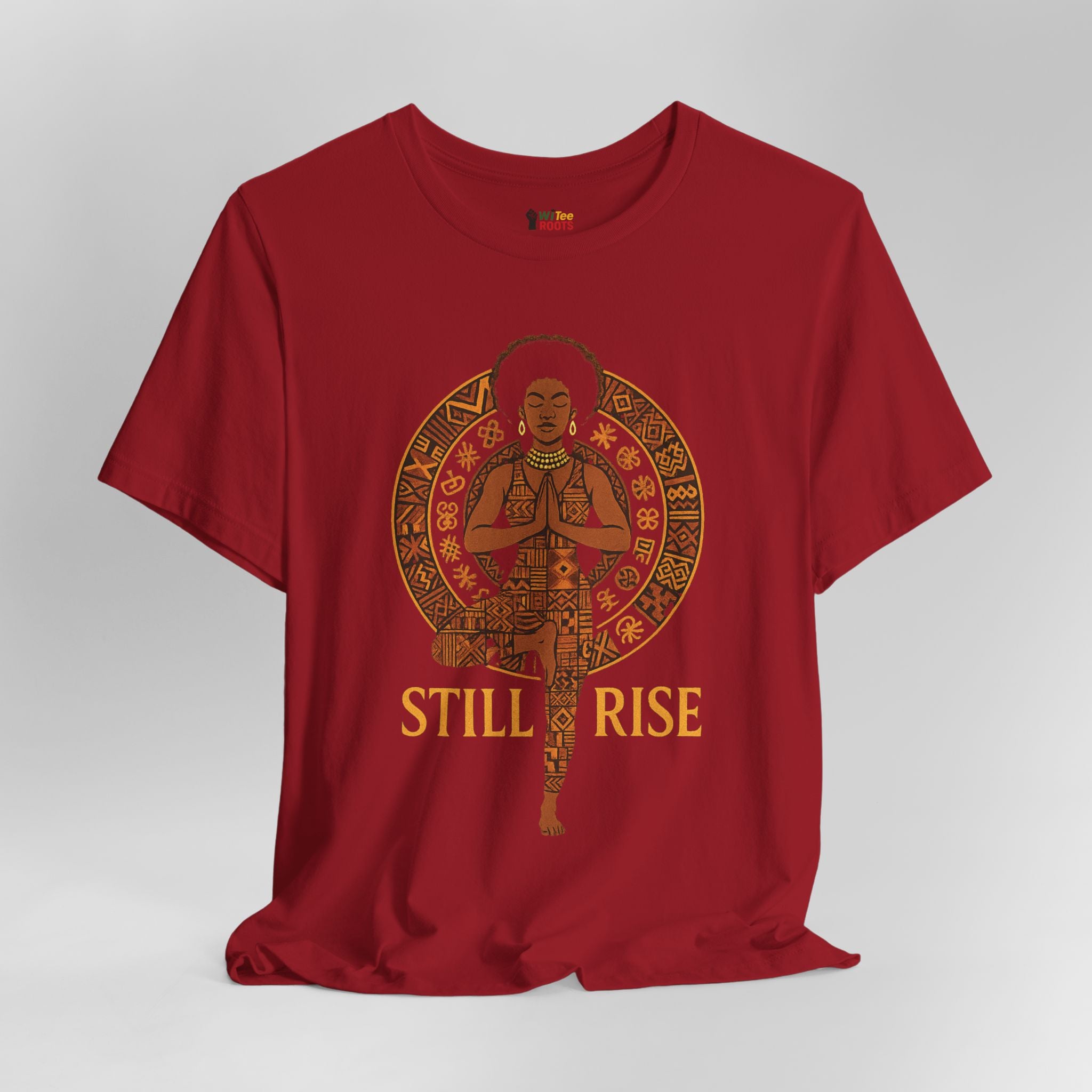 Red t-shirt with a graphic of a person in a meditative pose and 'STILL RISE' text on a grey background