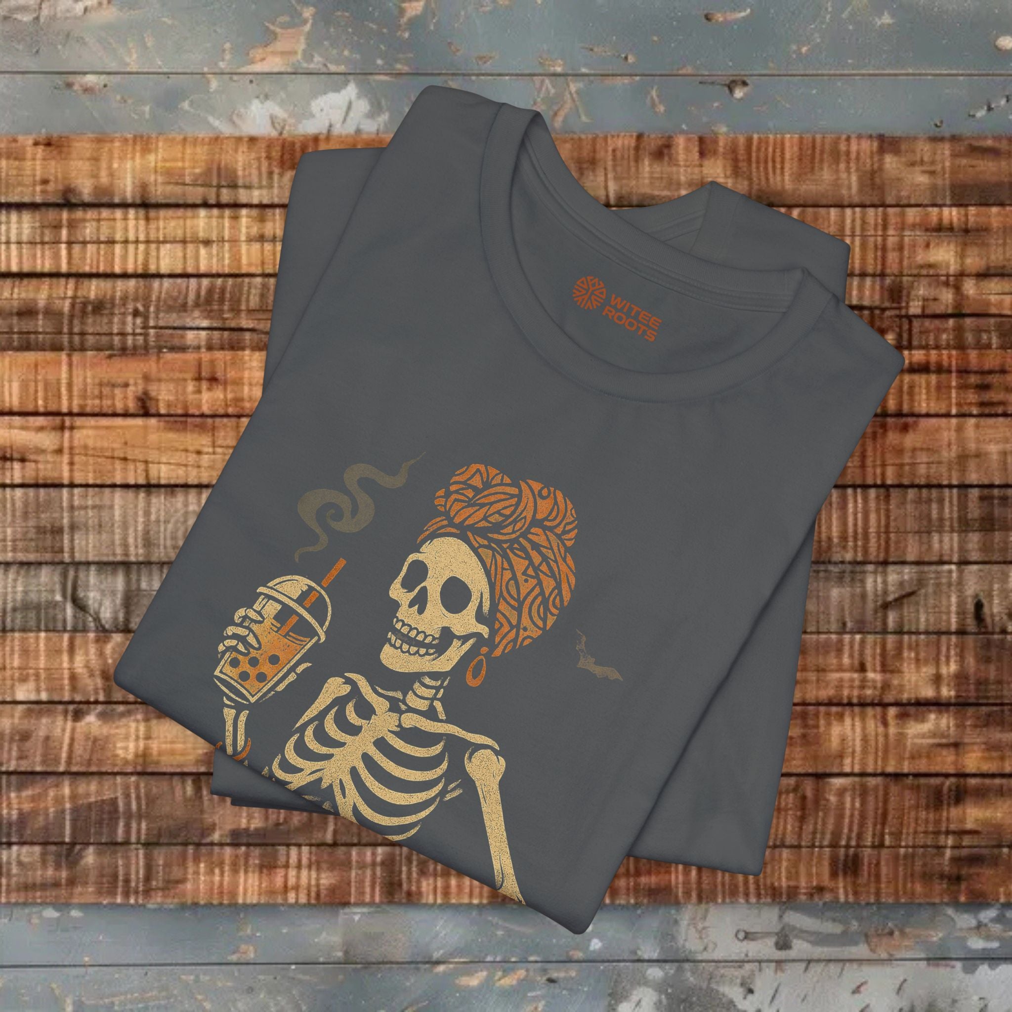 Folded t-shirt with skeleton and coffee cup design on a wooden surface