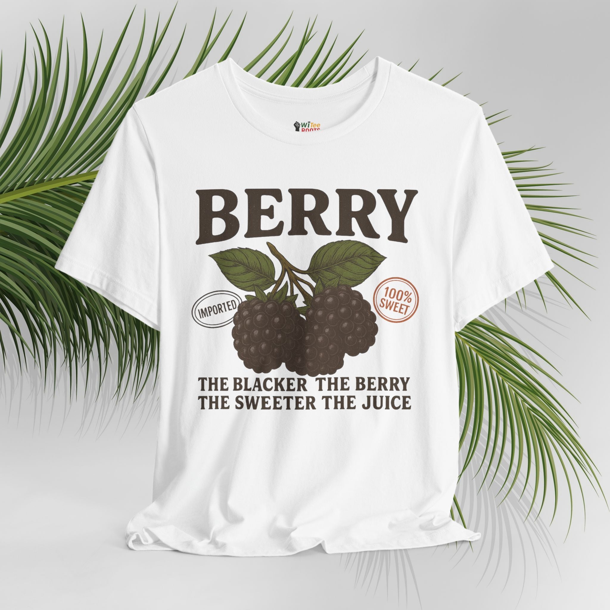 White t-shirt with berry graphic and text on a light gray background with green leaves.