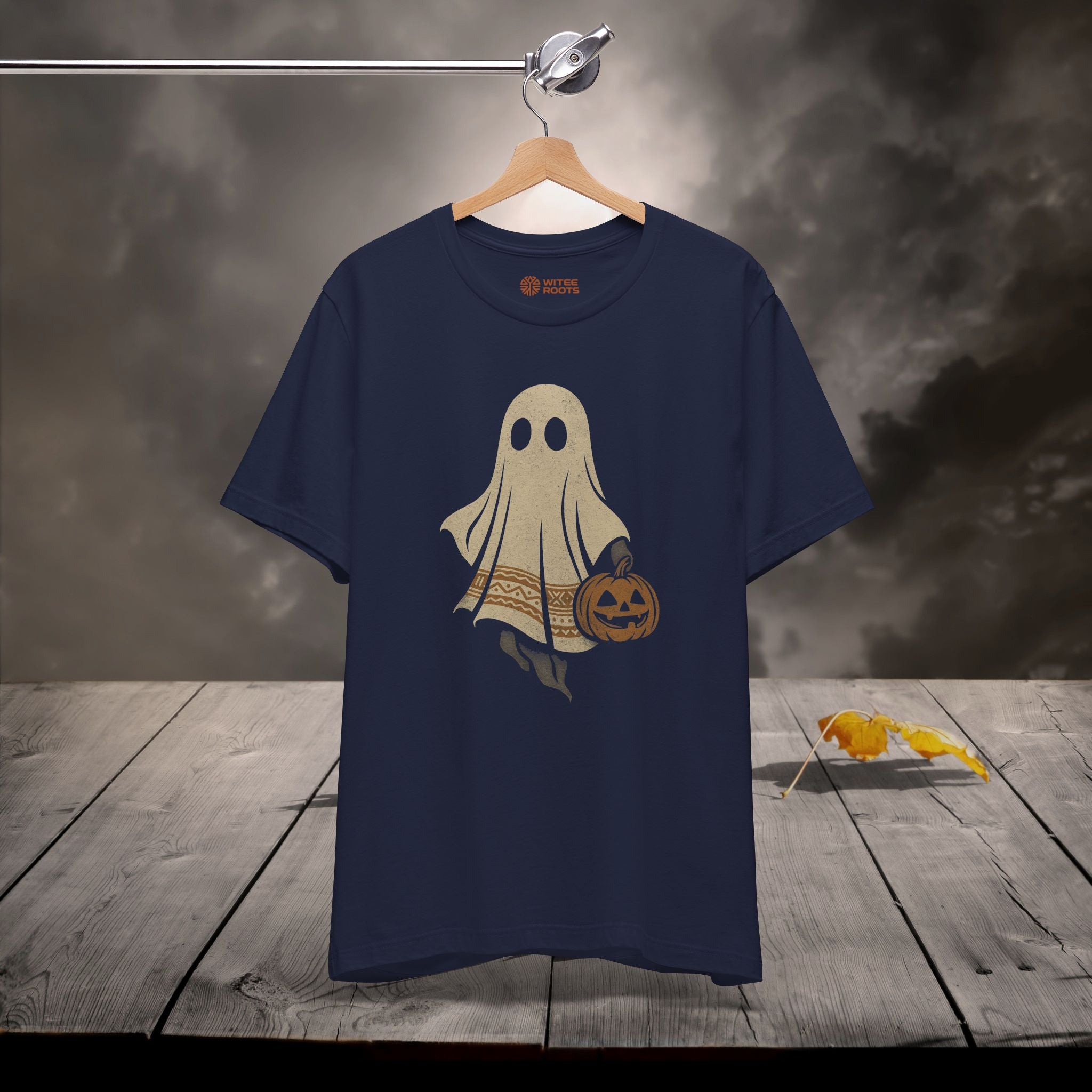 Navy blue t-shirt with a ghost design on a wooden surface with a dark background