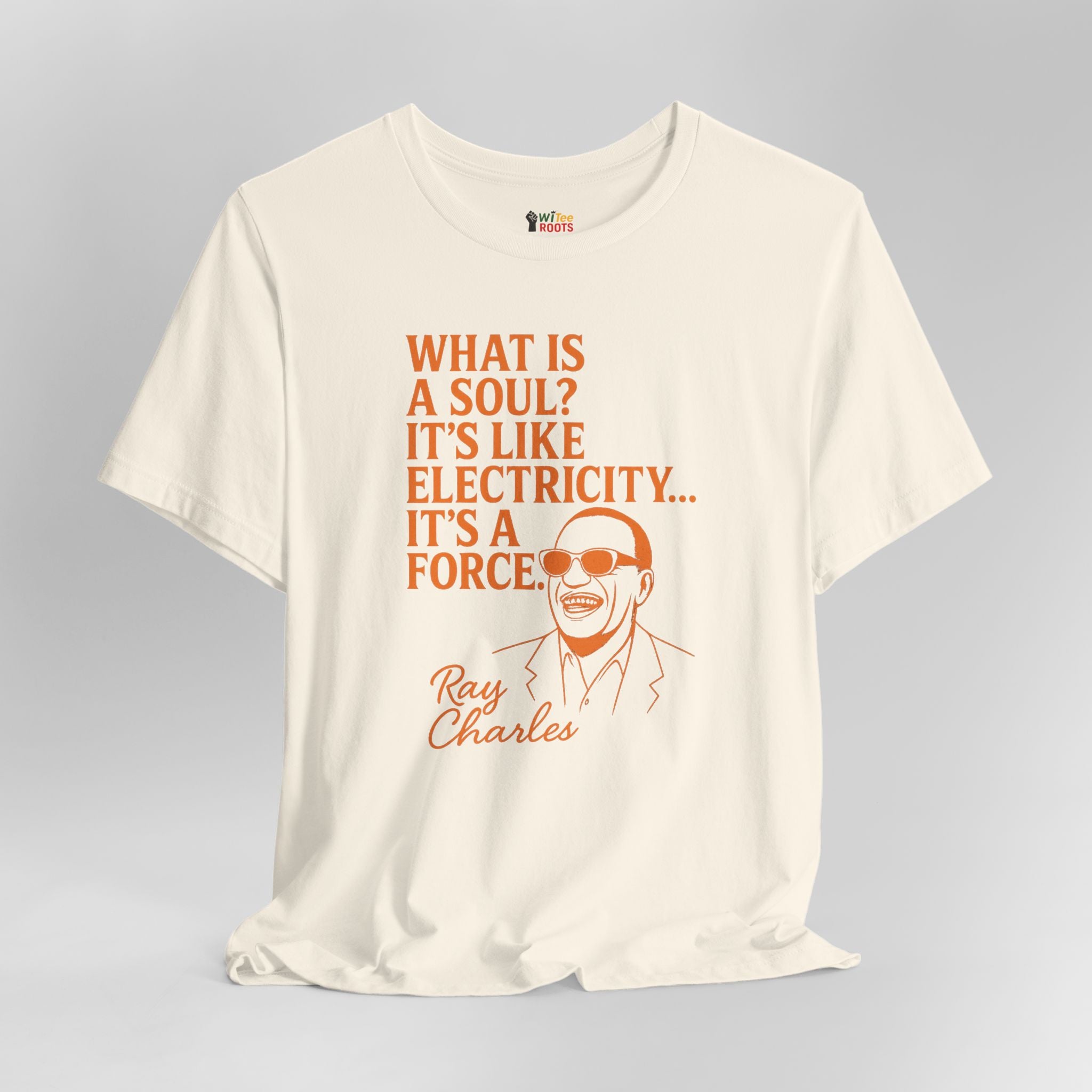 Beige t-shirt with orange text and Ray Charles illustration on a gray background