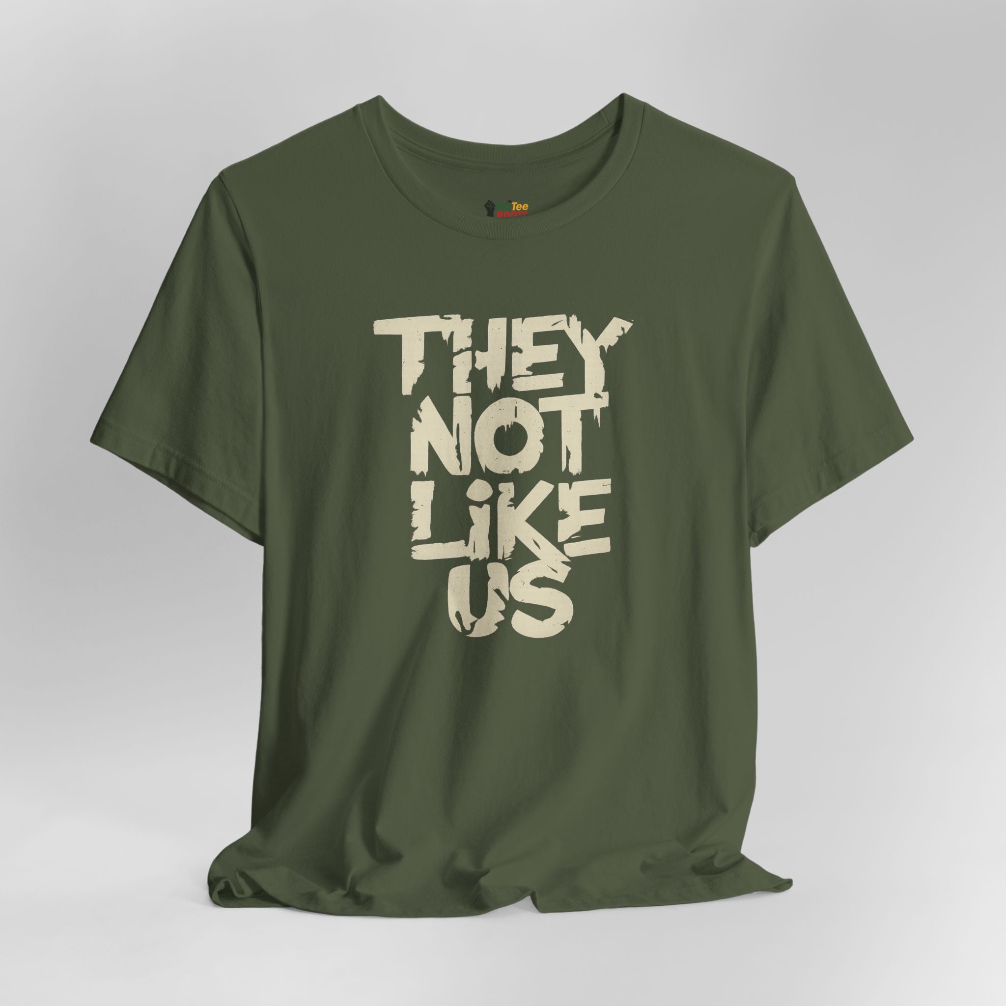 Green t-shirt with 'THEY NOT LIKE US' text on a gray background