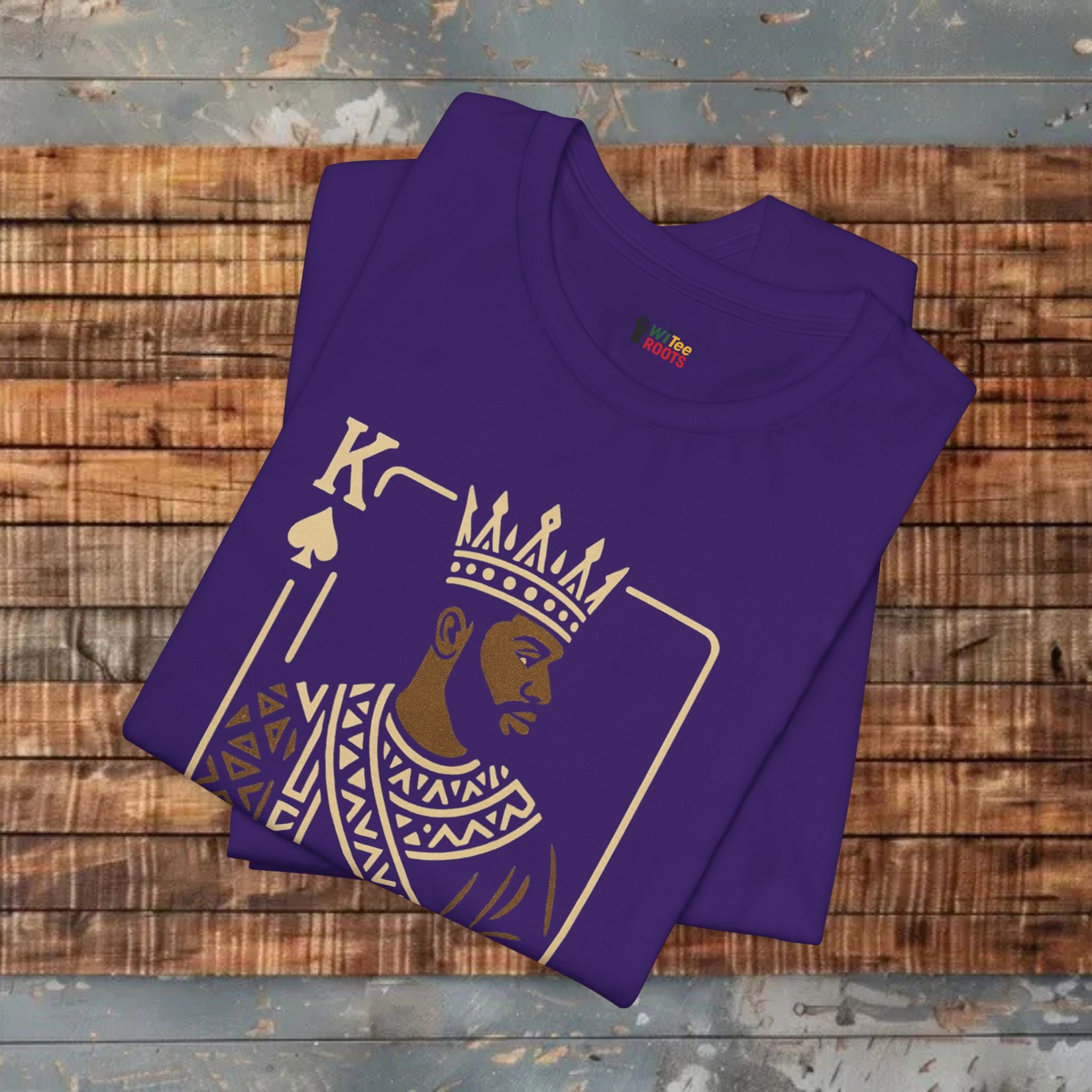 Folded purple t-shirt with a graphic design on a wooden surface