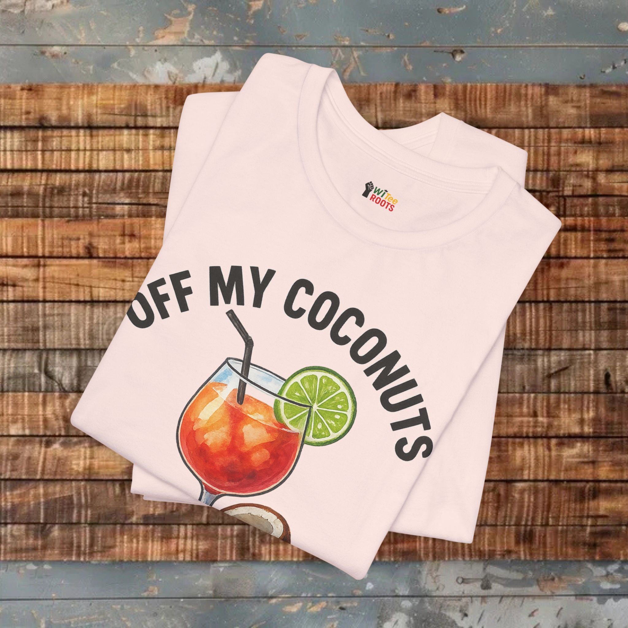 Folded t-shirt with 'Off My Coconuts' graphic on a wooden surface
