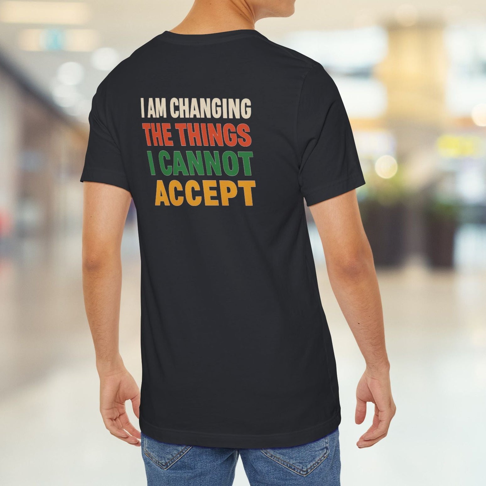 Person wearing a black t-shirt with a motivational message in colorful letters.