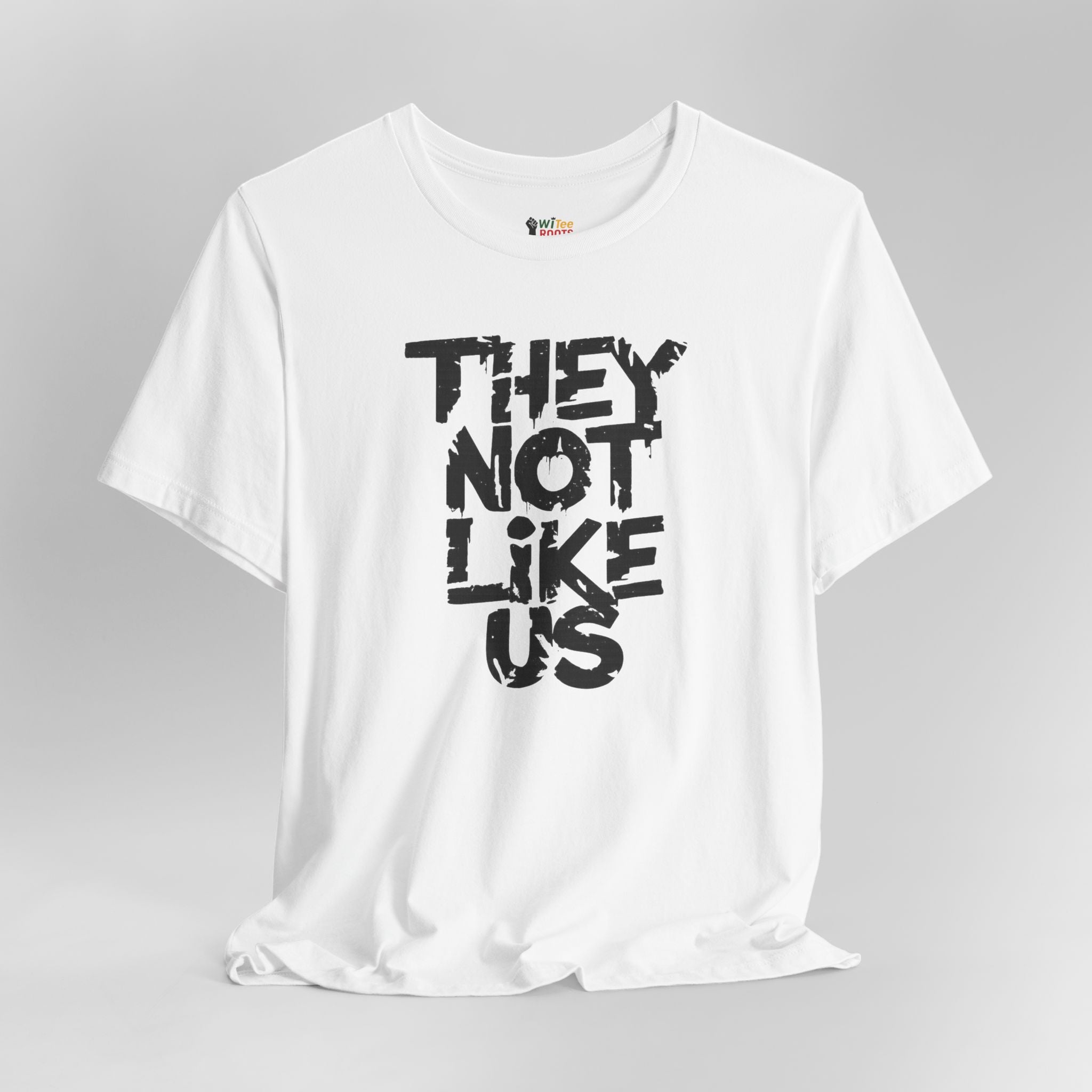 White t-shirt with black text 'THEY NOT LIKE US' on a gray background