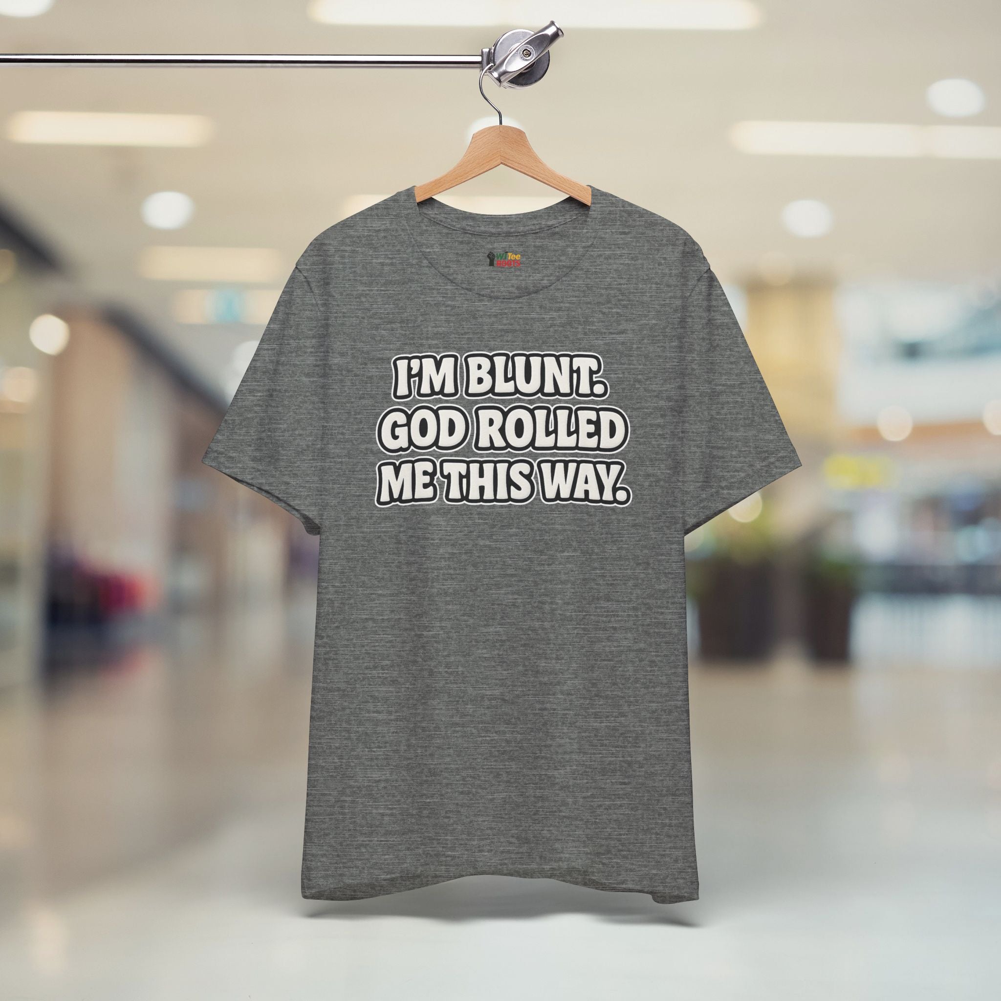 Gray t-shirt with humorous text on a hanger in a store setting