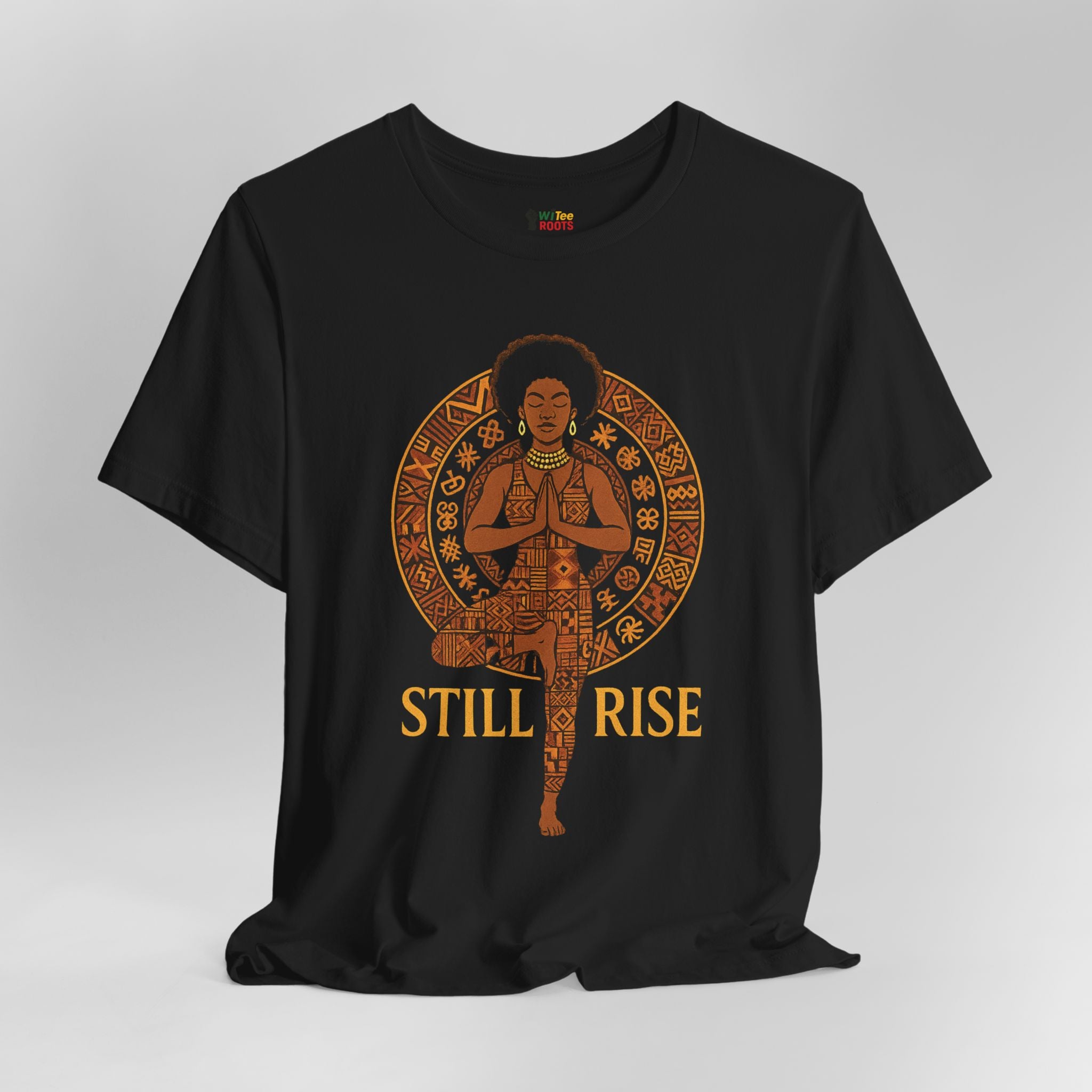 Black t-shirt with a graphic of a person in a meditative pose and 'STILL RISE' text on a gray background
