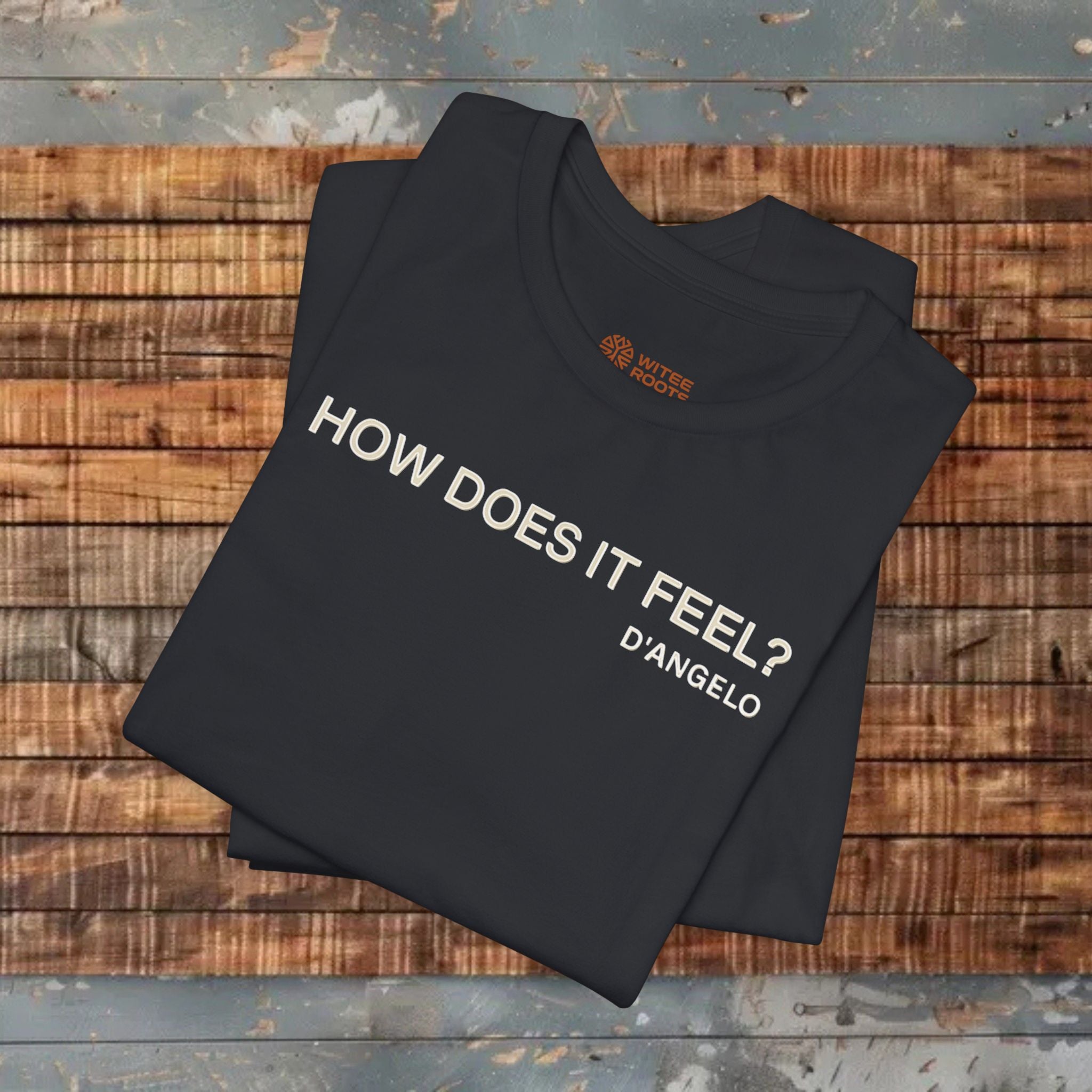 Folded black t-shirt with text on a wooden surface