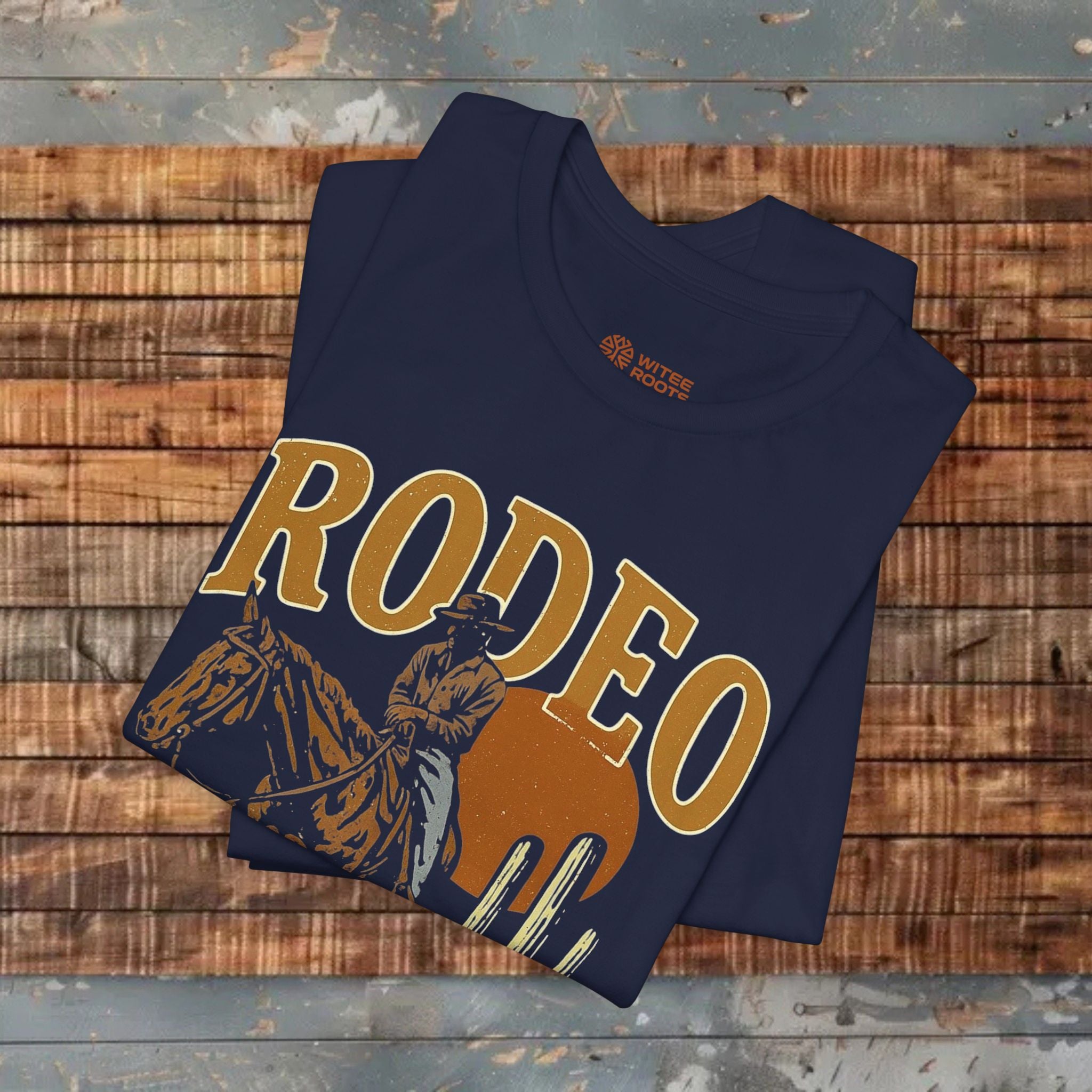 Folded navy blue t-shirt with 'RODEO' and horse graphic on a wooden surface