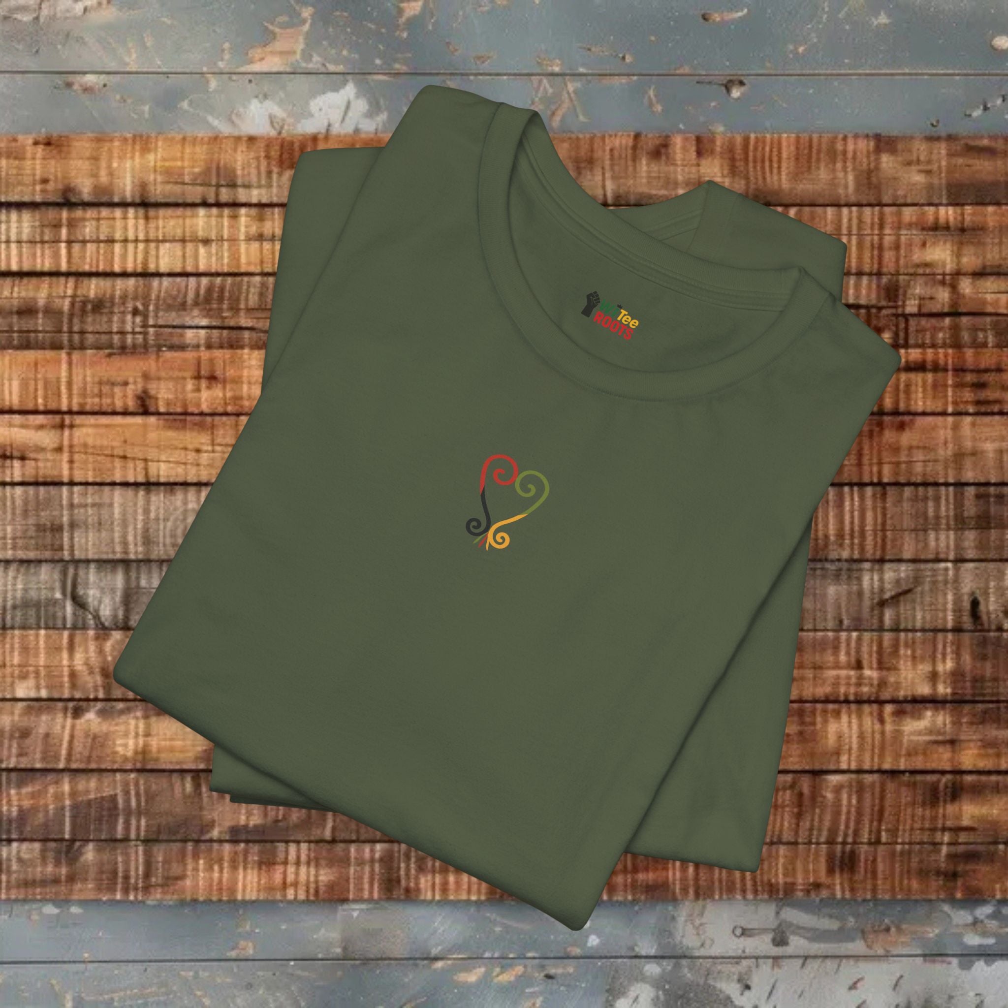 Folded green t-shirt with a colorful design on a wooden surface