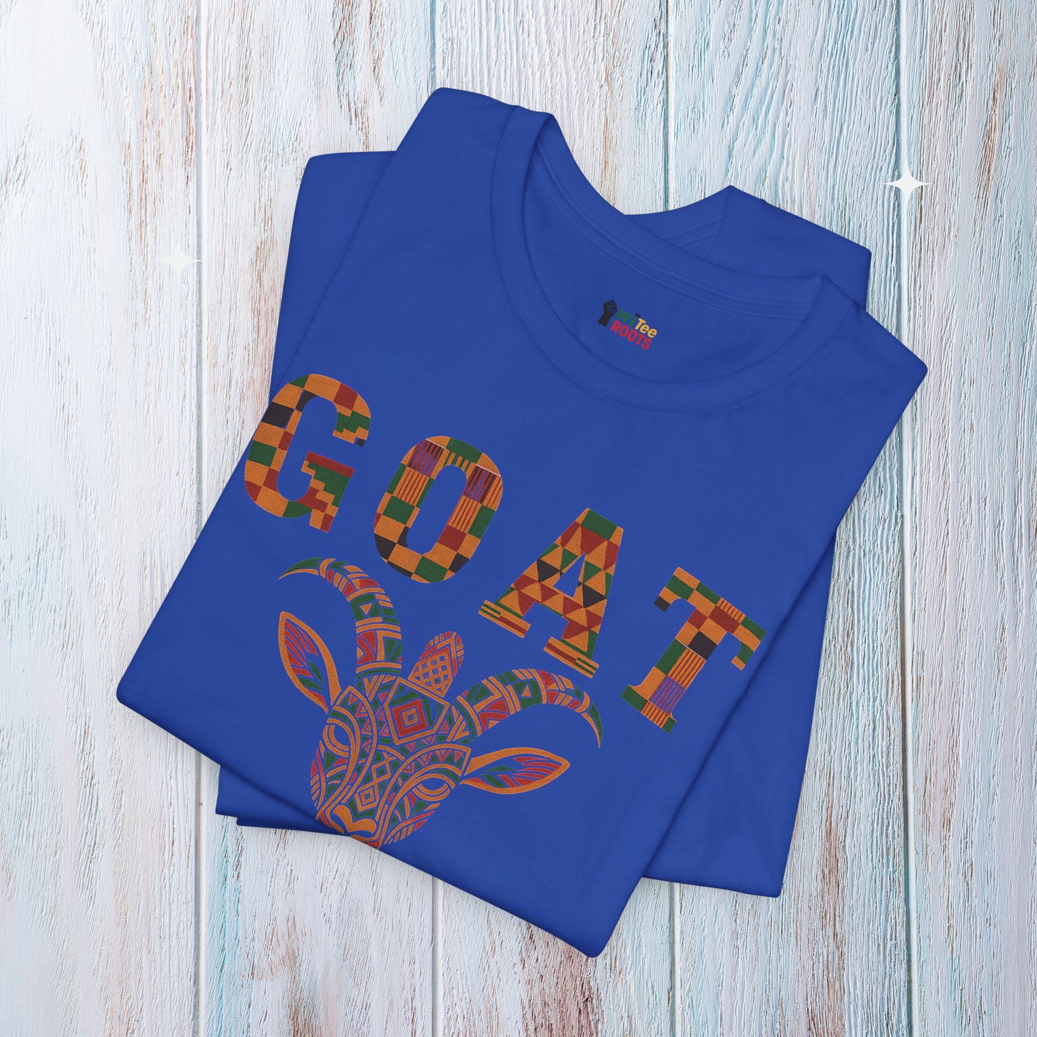 Blue t-shirt with colorful 'GOAT' design on a wooden surface