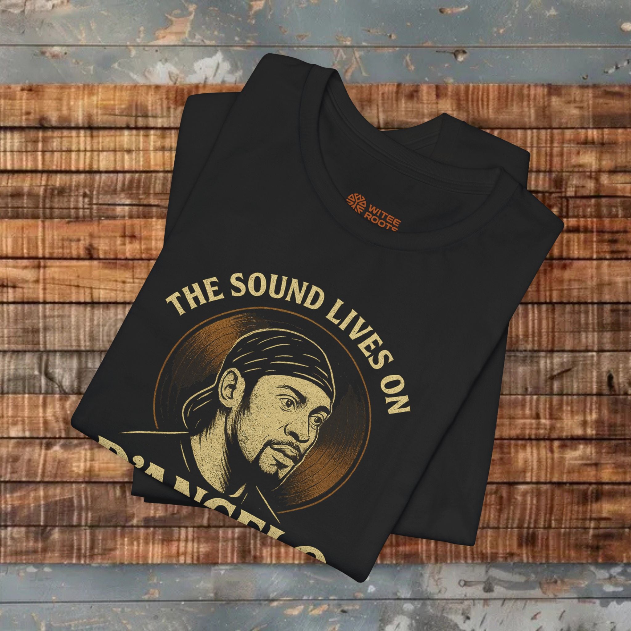 Black t-shirt with graphic design and text 'The Sound Lives On' on a wooden surface