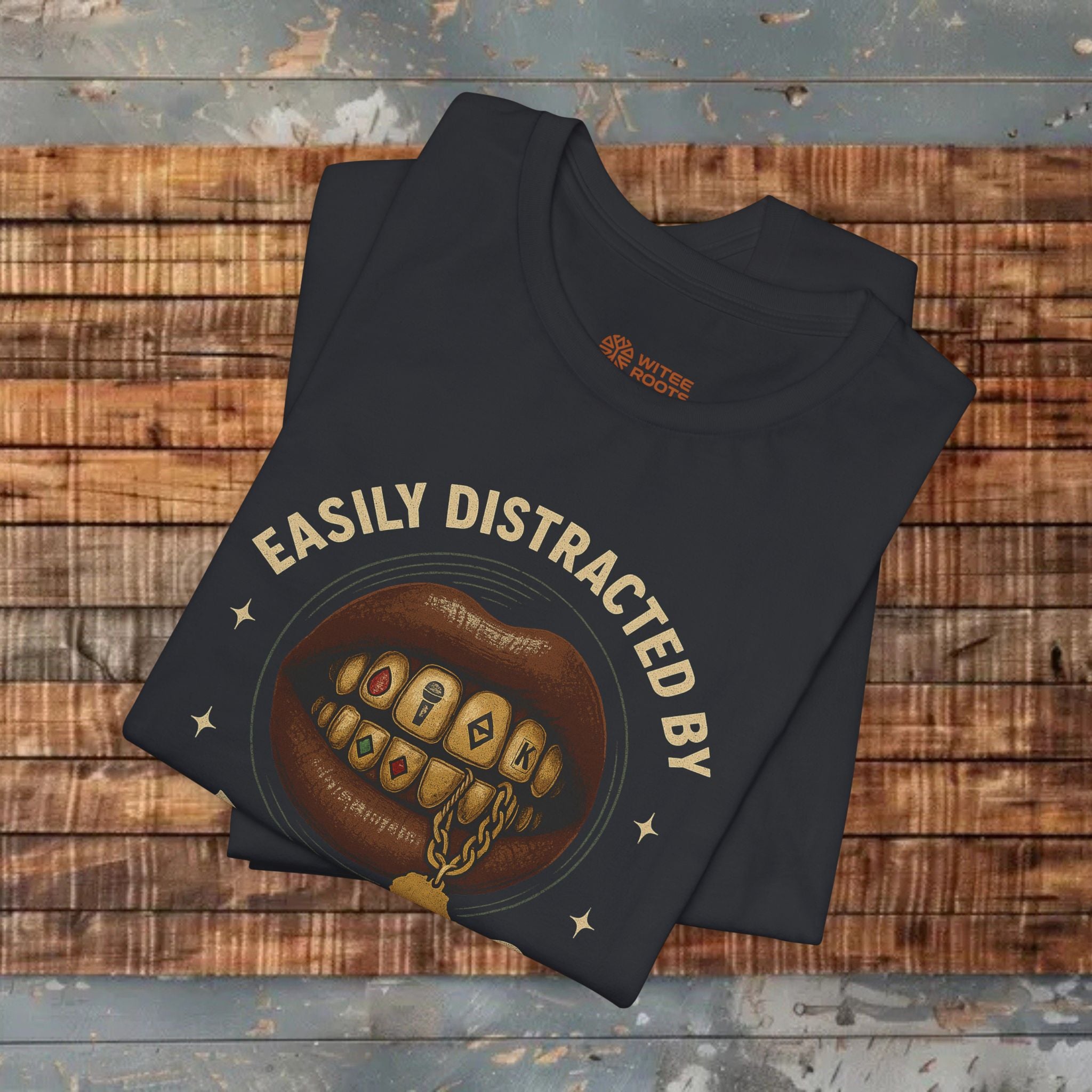 Black t-shirt with graphic design and text on a wooden surface