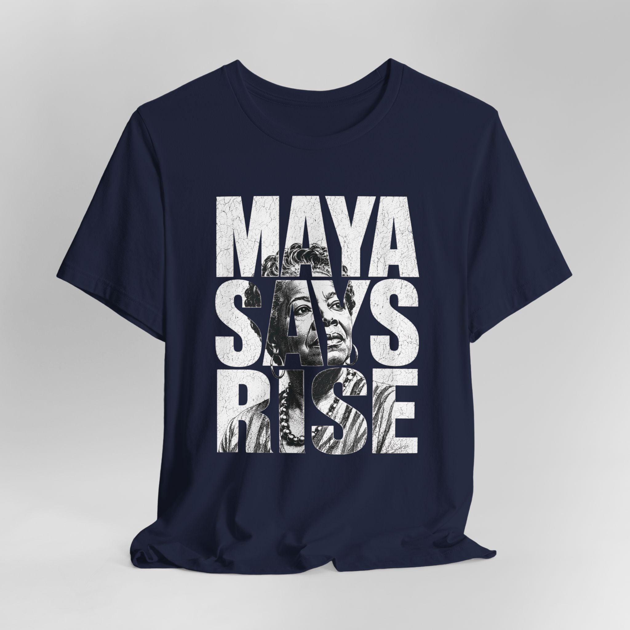 Navy blue t-shirt with 'MAYA SAYS RISE' text and graphic on a gray background