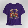 Purple t-shirt with 'Seasons Greetings' graphic on a gray background