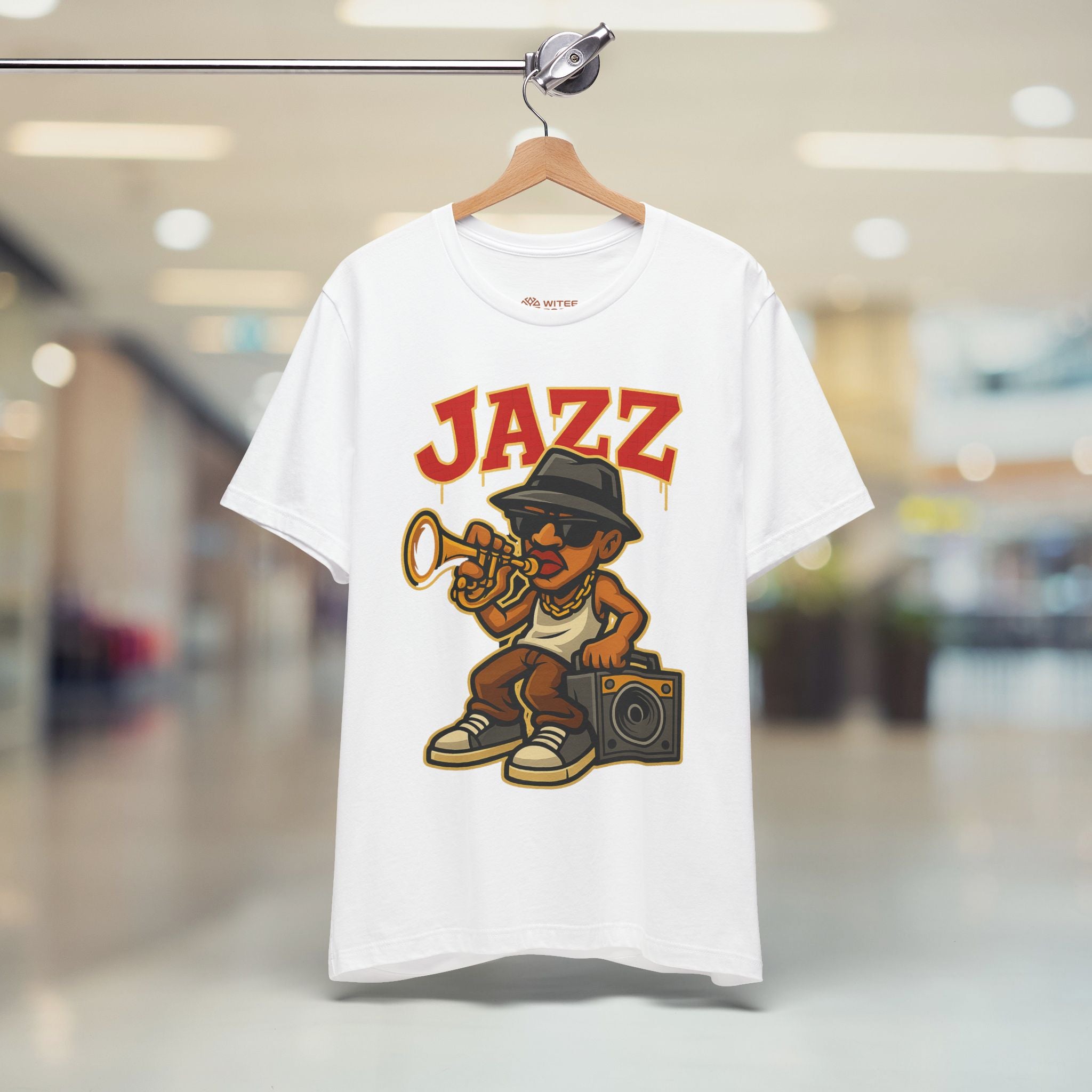 White t-shirt with a 'Jazz' graphic design featuring a person playing a trumpet, hanging on a hanger in a store.