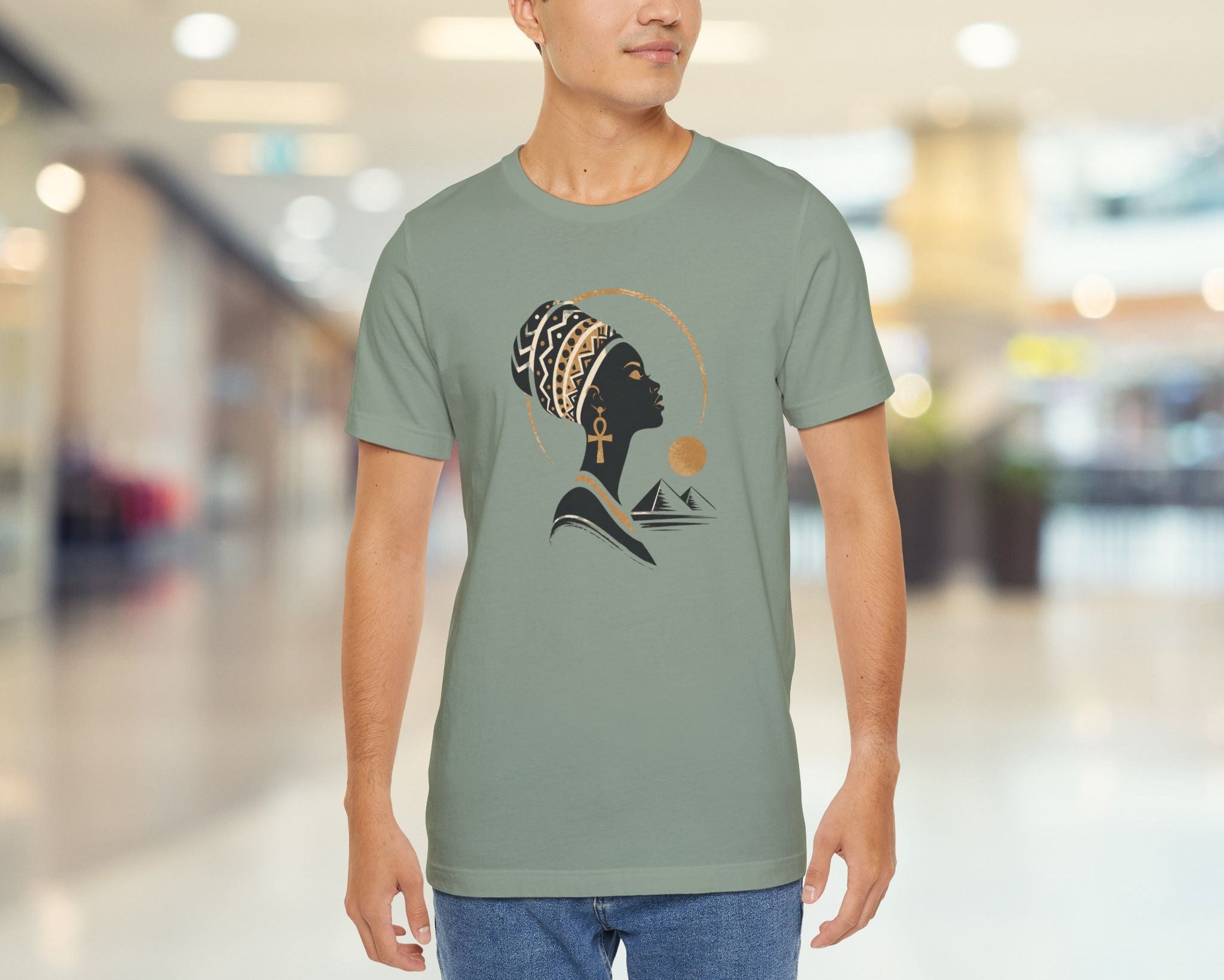 Man wearing a green t-shirt with a graphic design in a blurred indoor setting