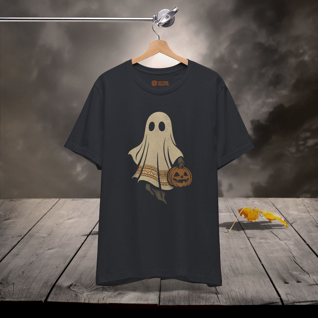 Black t-shirt with a ghost holding a pumpkin design on a wooden surface with a dark background.