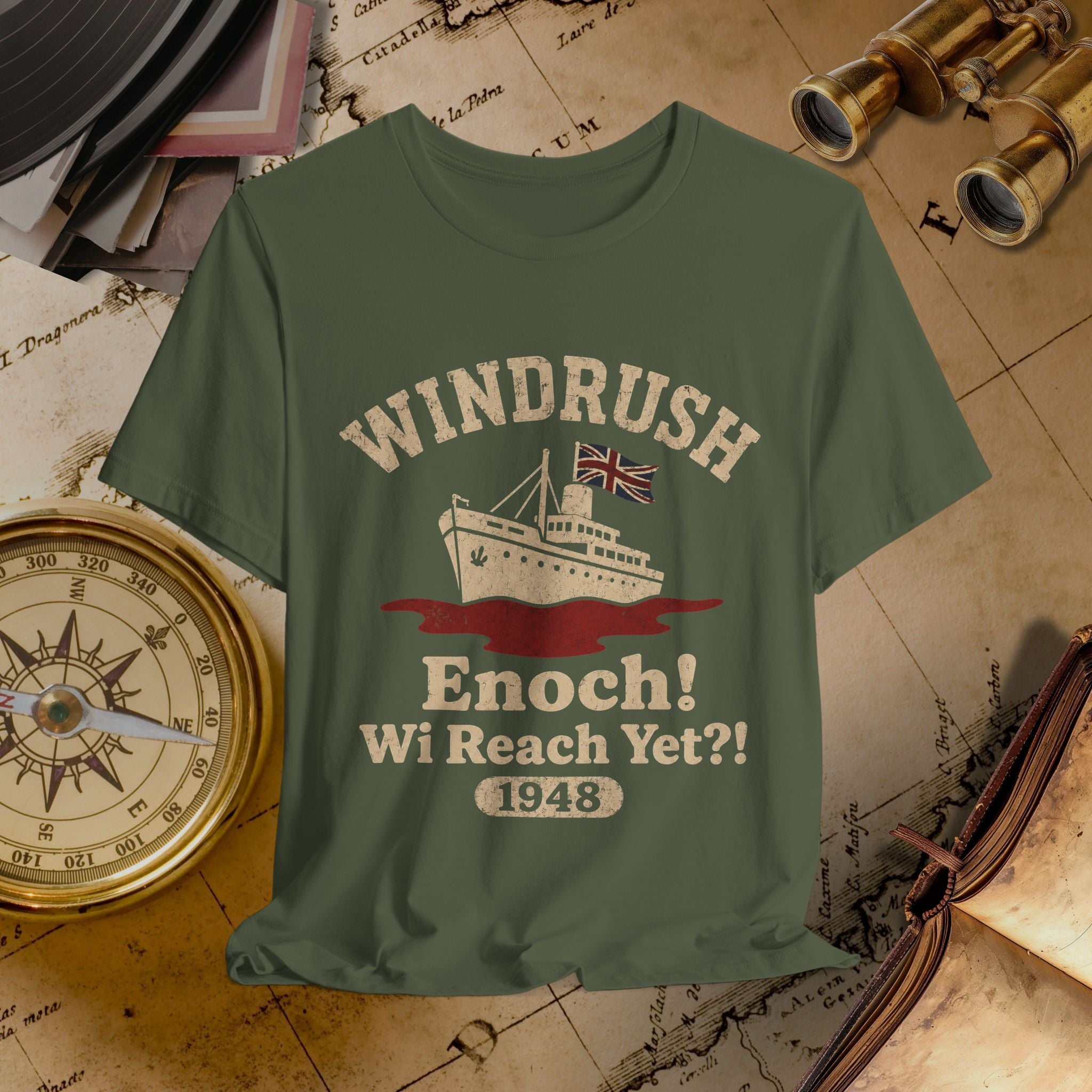 Green t-shirt with 'Windrush Enoch! Wi Reach Yet?! 1948' design on a vintage map background.