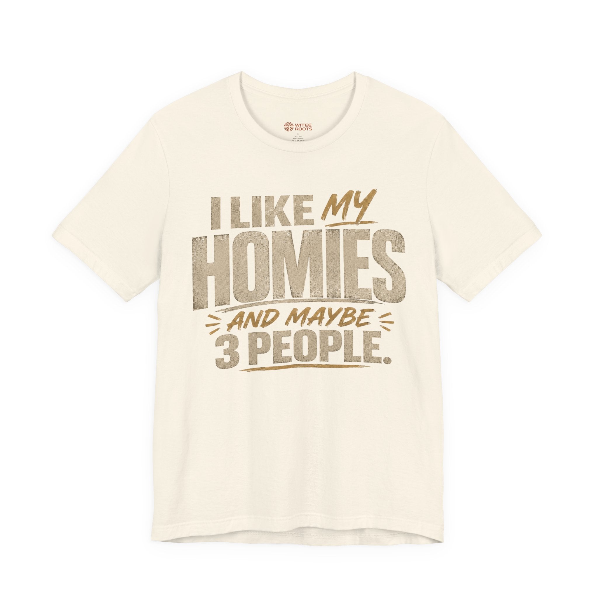 A beige graphic t-shirt displayed on a white background. The shirt features a humorous slogan printed in white and tan lettering: 'I LIKE MY HOMIES and maybe 3 PEOPLE.