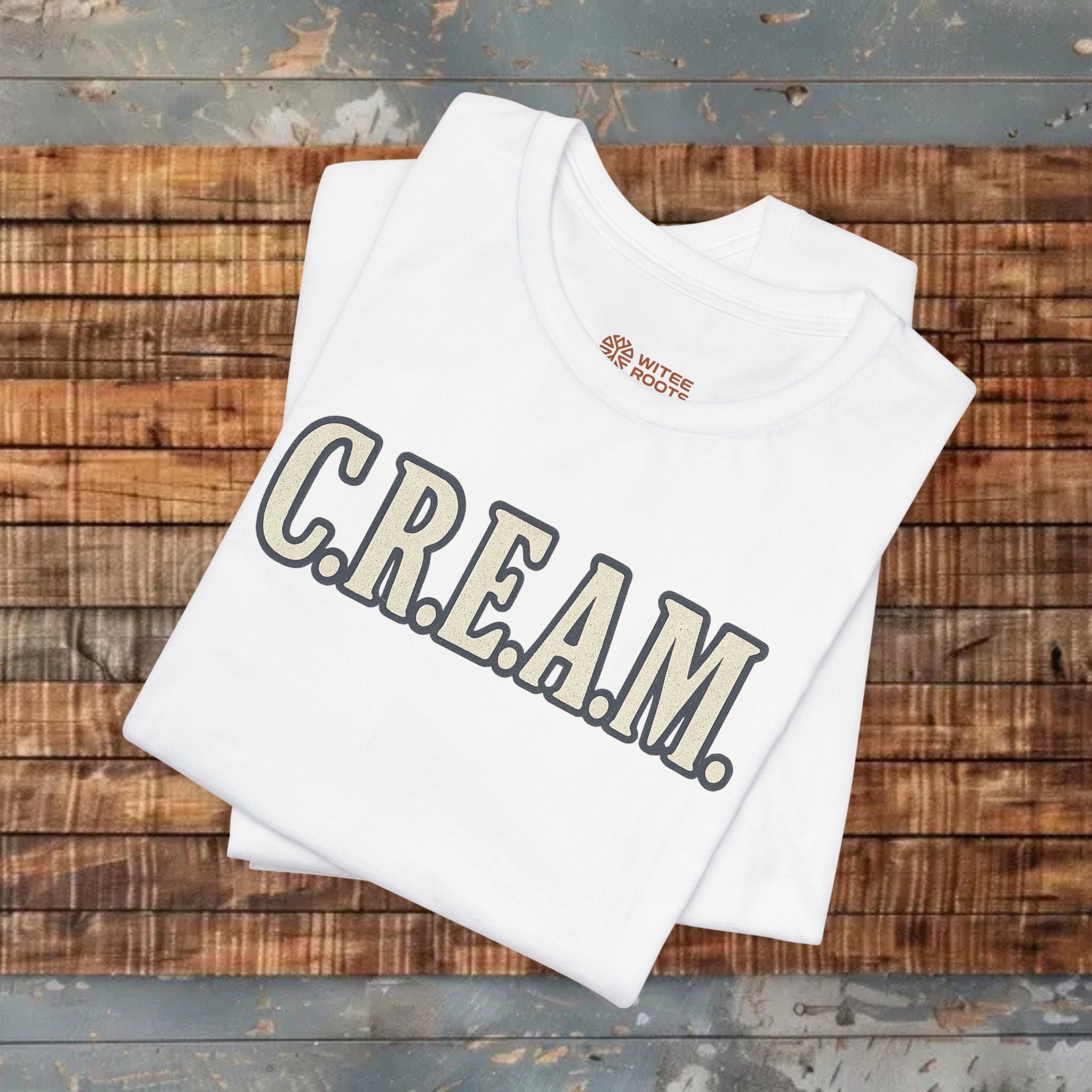 White tank top with 'C.R.E.A.M.' text and logo on a wooden surface