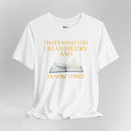 White t-shirt with a graphic of an open book and text on a gray background