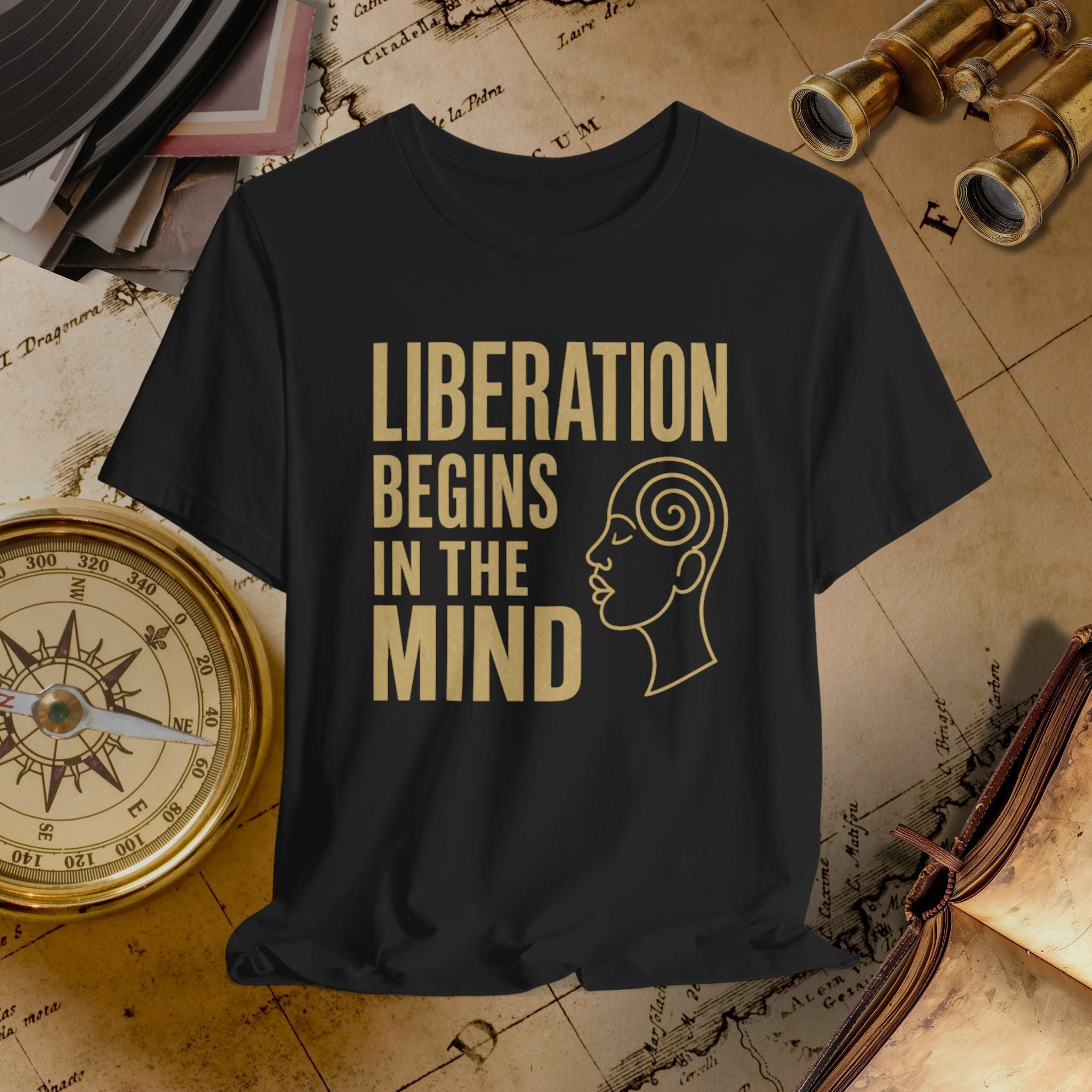 Black t-shirt with 'Liberation Begins in the Mind' text and a face outline on a vintage map background.