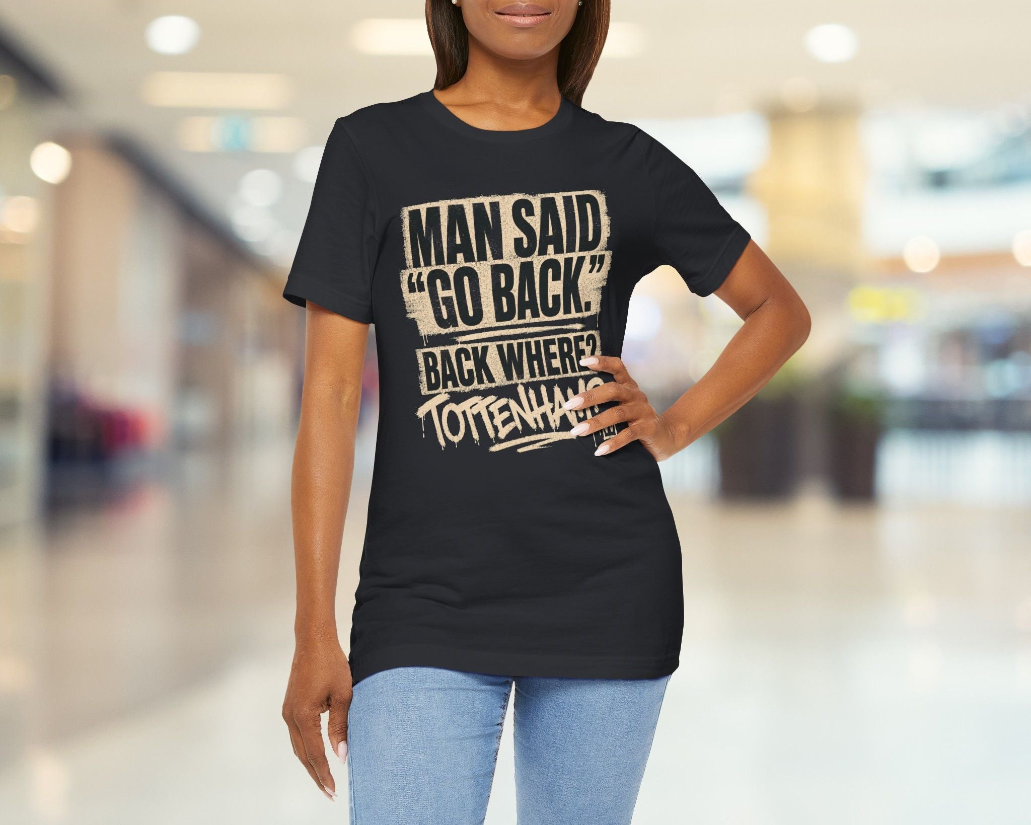 Woman wearing a black t-shirt with text in a blurred indoor setting