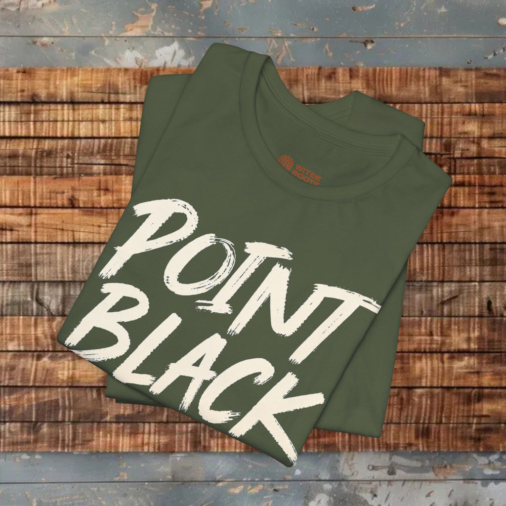 An olive green folded t-shirt with 'POINT BLACK' printed in a large white brush-stroke font, displayed on a rustic wooden plank surface.