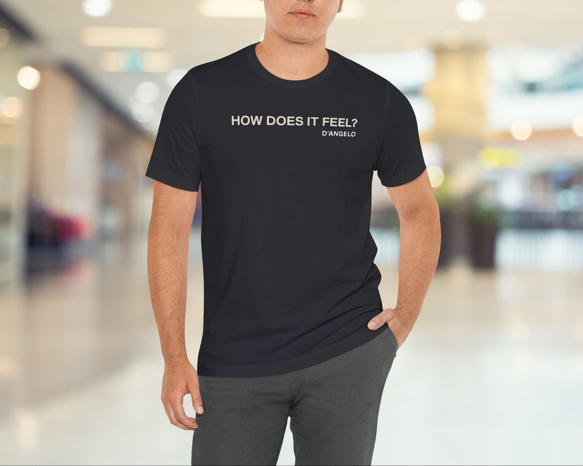 Man wearing a black t-shirt with text in a blurred indoor setting