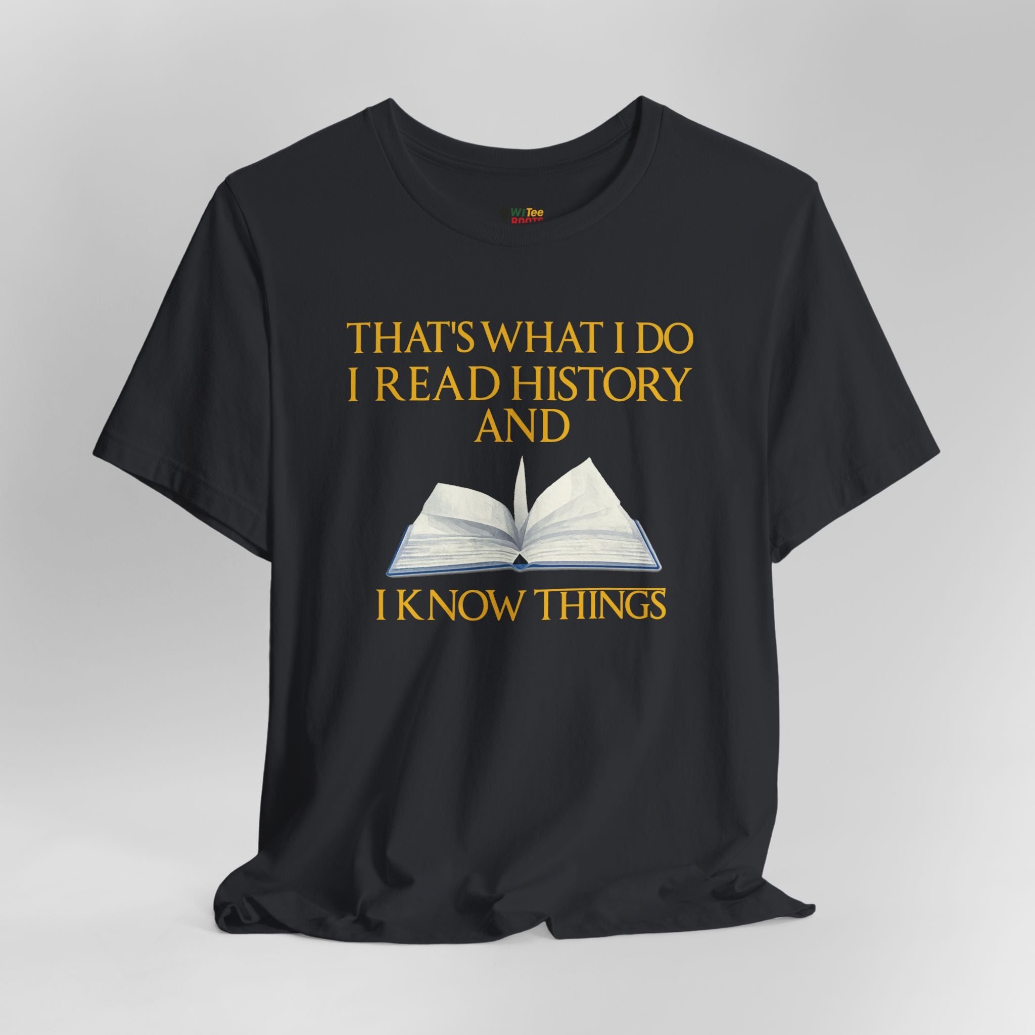 Black t-shirt with yellow text and an open book graphic on a gray background
