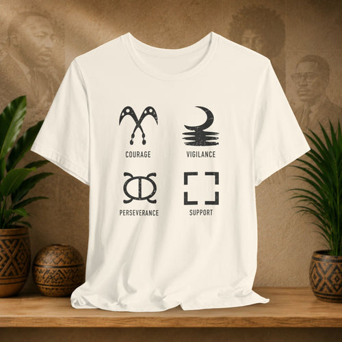 Beige t-shirt with black symbols and text on a wooden surface with plants and a textured wall background