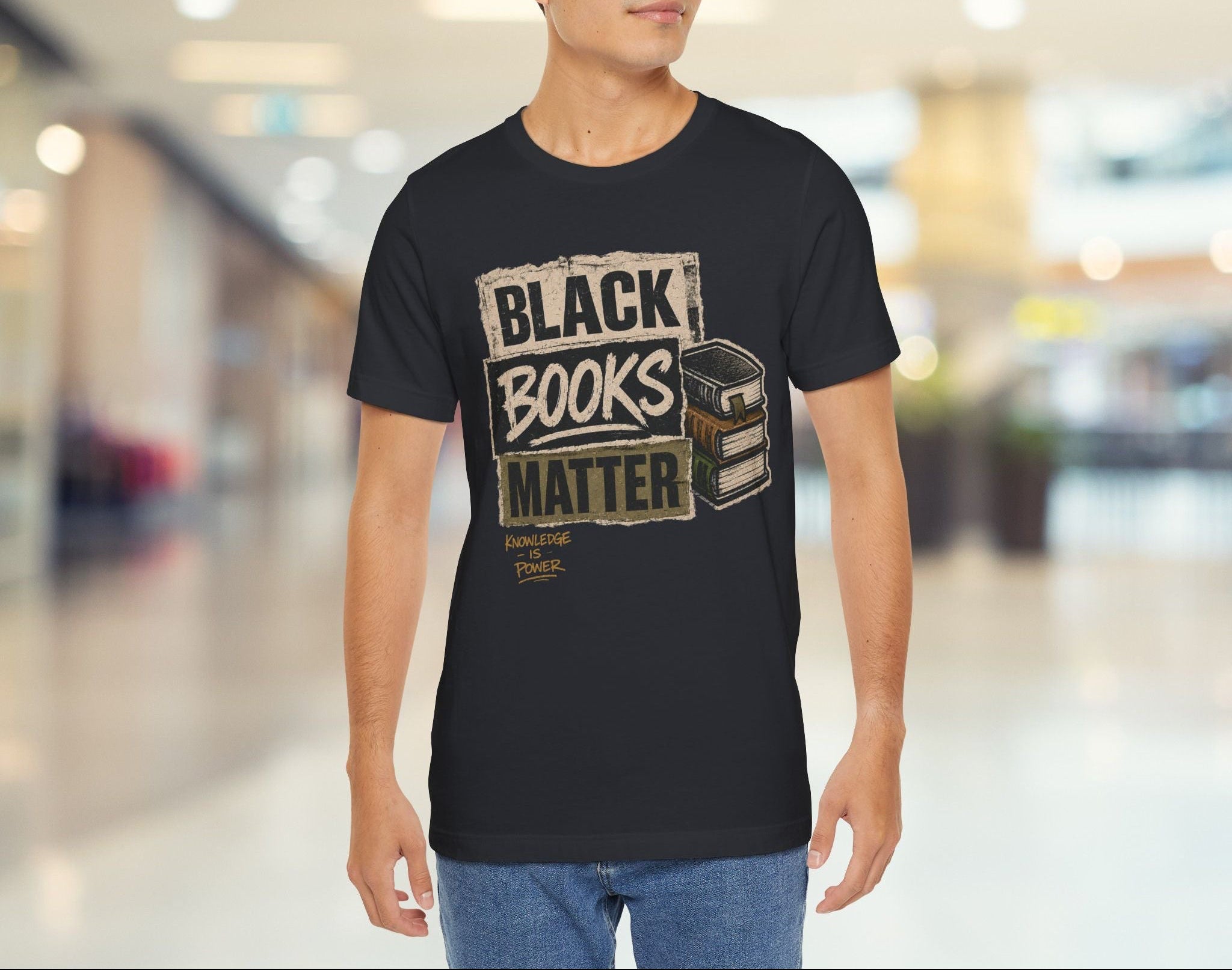 Person wearing a black t-shirt with 'Black Books Matter' text in a mall setting