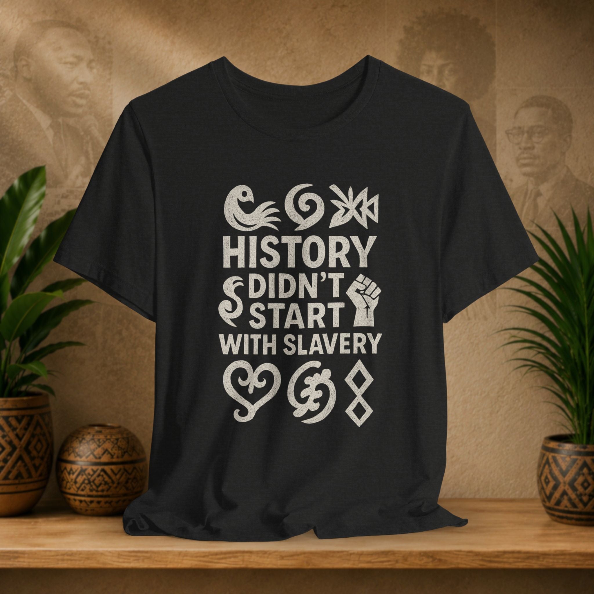 Black t-shirt with white text and graphics on a wooden surface with a decorative background