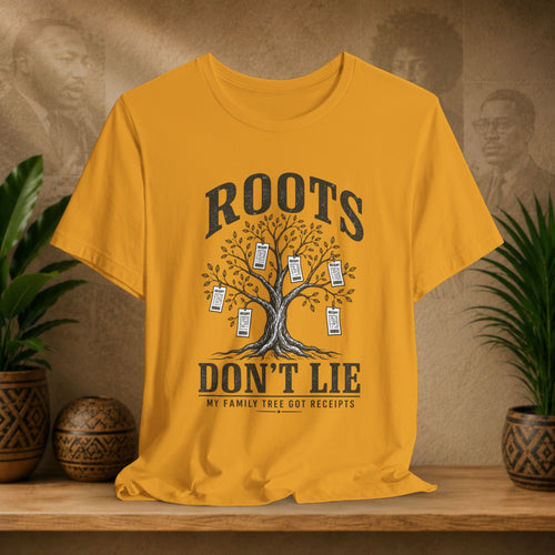 Mustard t-shirt with family tree graphic and text on a wooden surface with plants and decorative items.