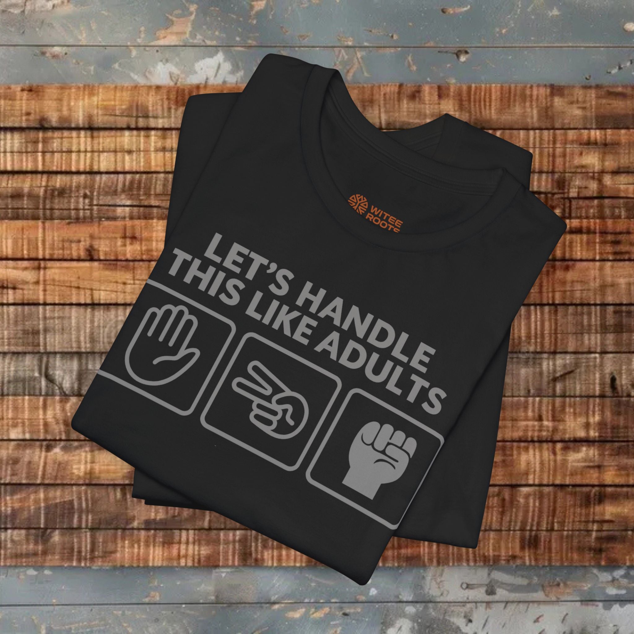 Black t-shirt with text and icons on a wooden surface