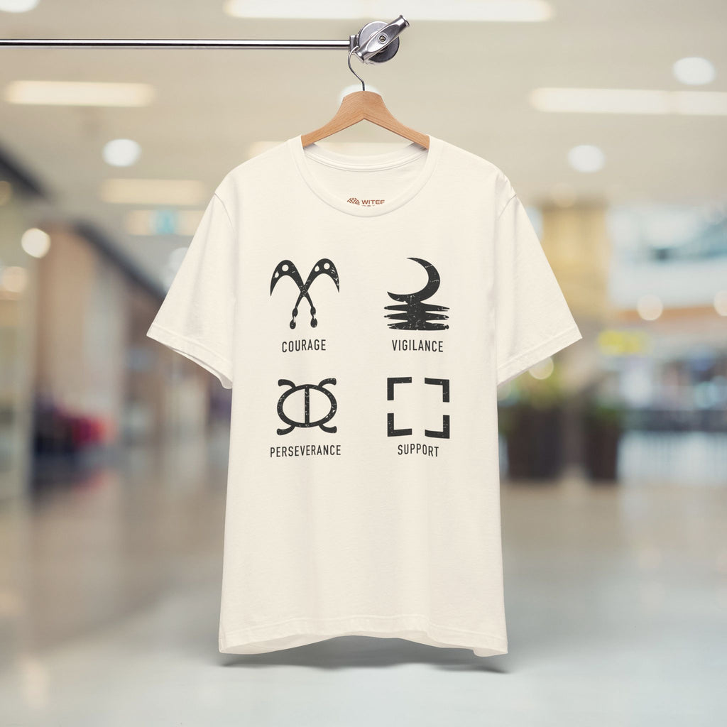 Sand t-shirt with black graphics and text on a hanger in a blurred indoor setting