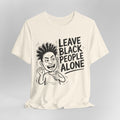 Cream t-shirt with a graphic and text 'Leave Black People Alone' on a gray background
