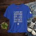 Blue t-shirt with text on a wooden surface with jeans and sneakers.