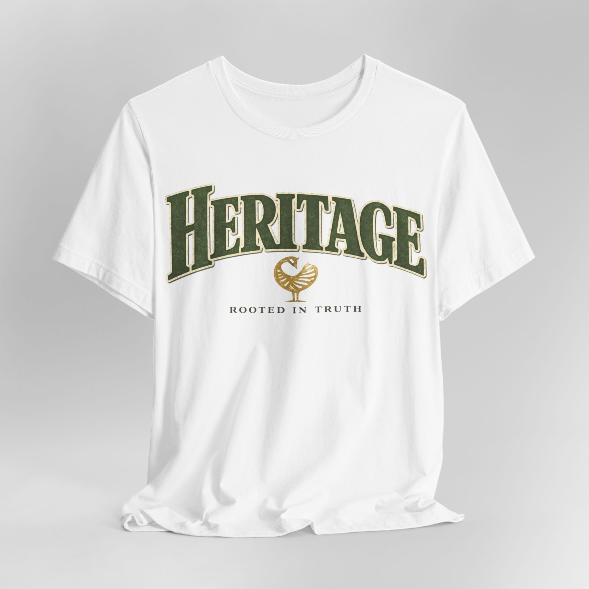 White t-shirt with 'Heritage Rooted in Truth' text and logo on a gray background