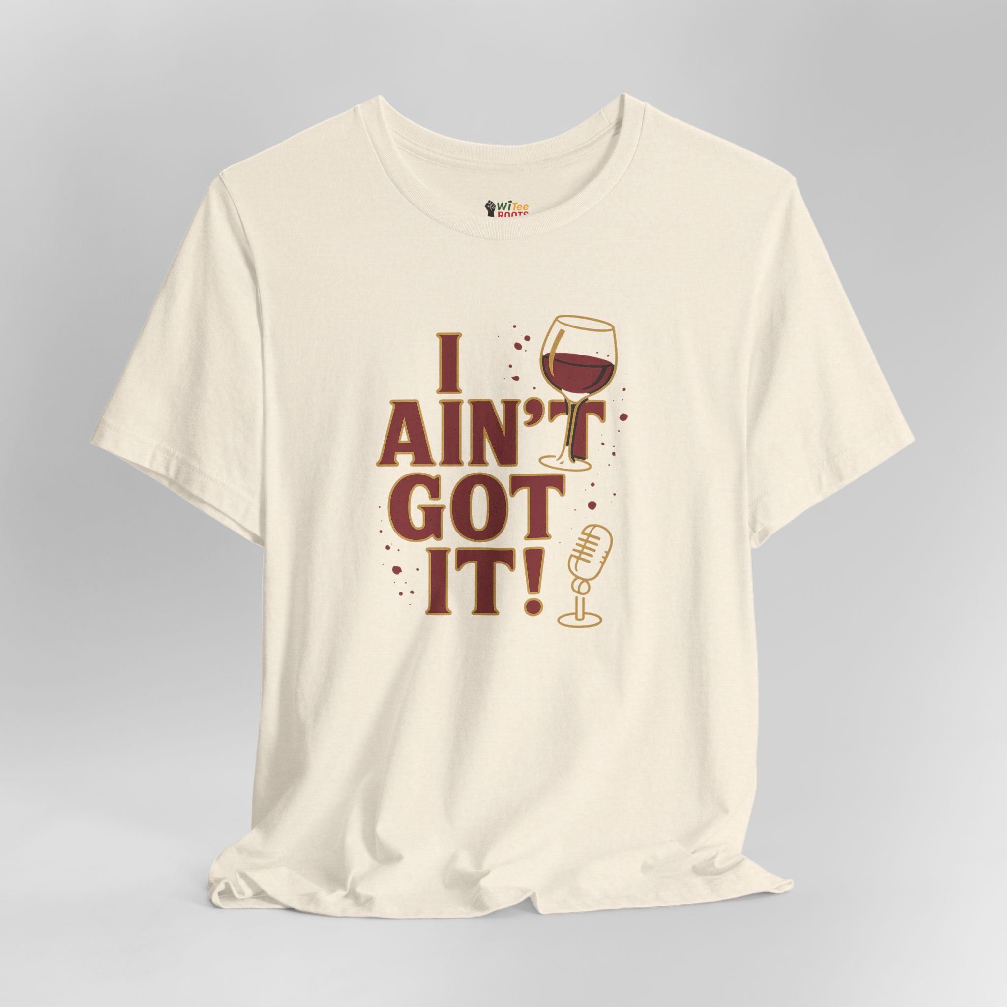 Beige t-shirt with 'I Ain't Got It!' text and wine glass graphic on a gray background