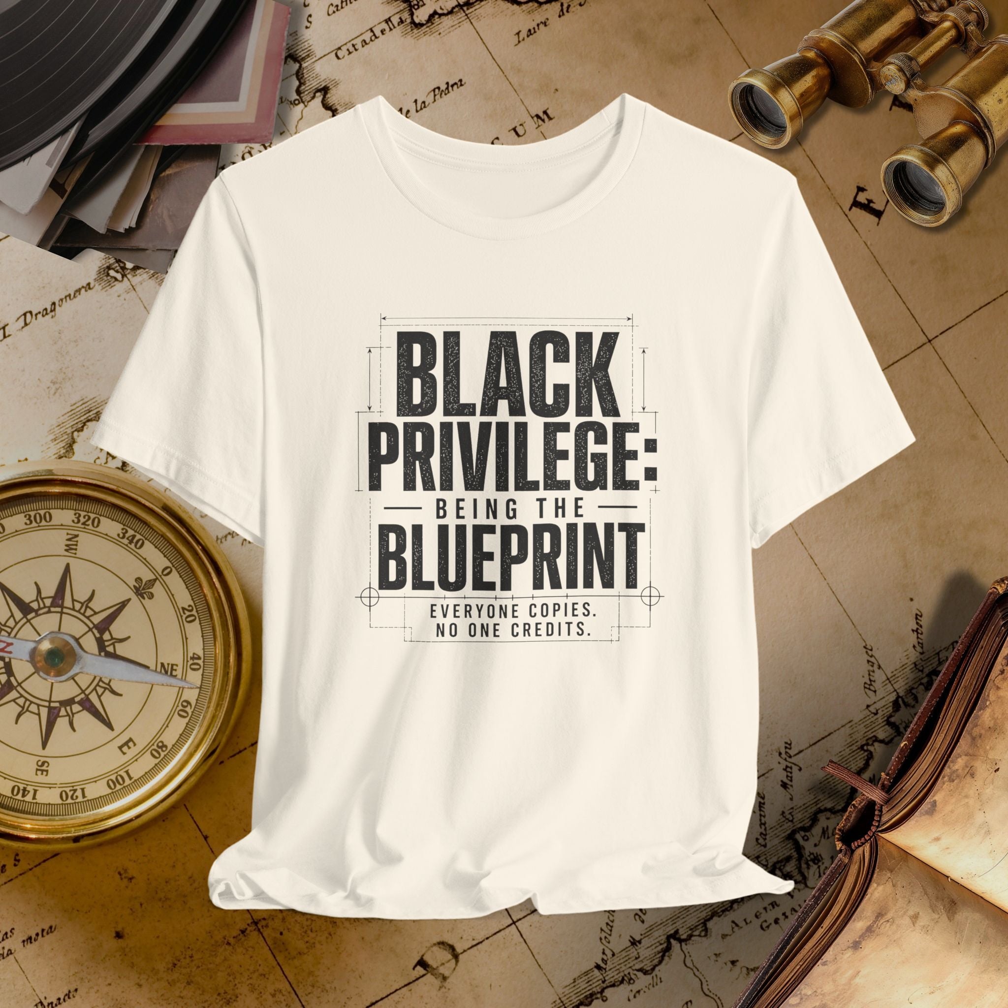 Beige t-shirt with 'Black Privilege: Being the Blueprint' text on a vintage map background