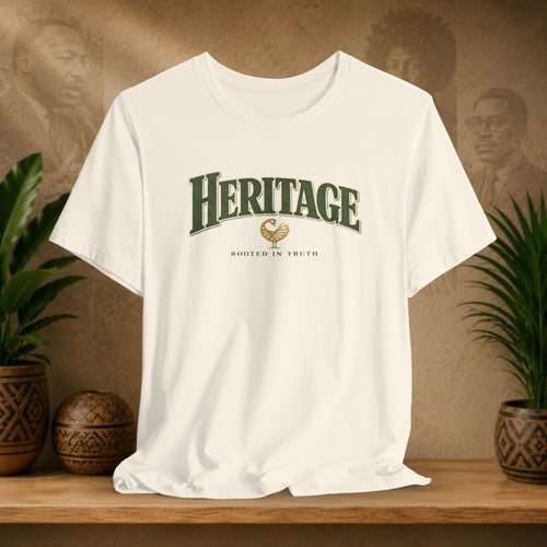 Beige t-shirt with 'Heritage' text on a wooden shelf with plants and a textured wall background
