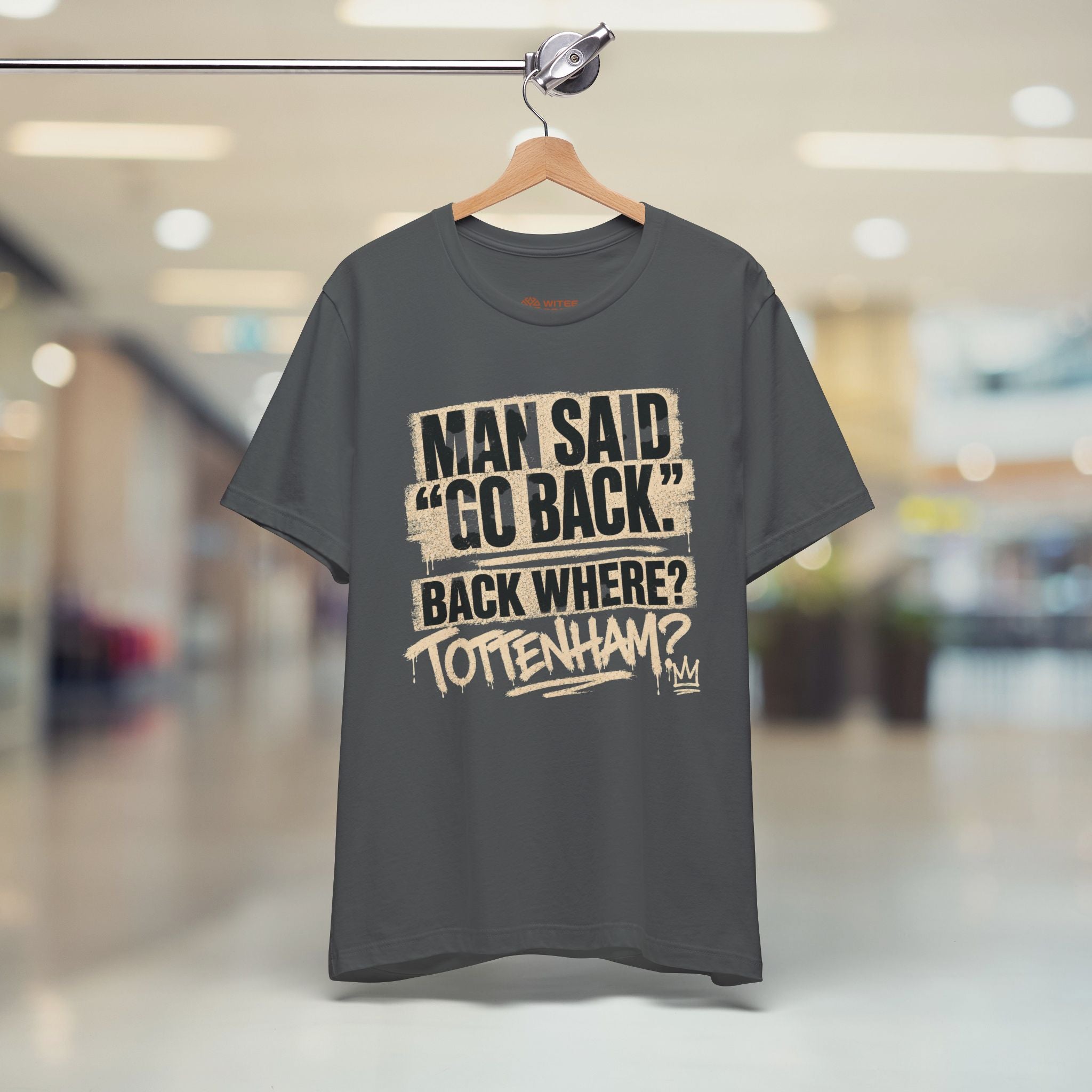 Gray t-shirt with printed text on a hanger in a store setting
