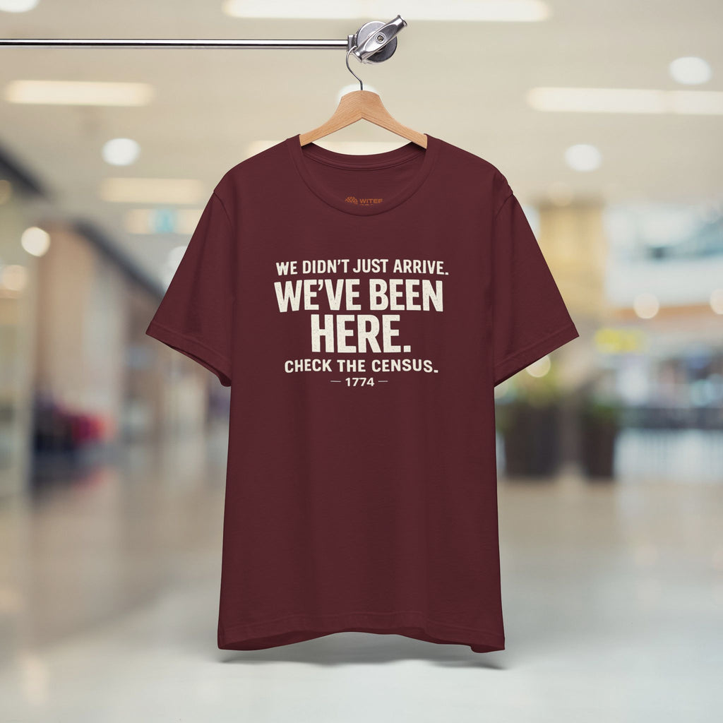 Maroon t-shirt with humorous text on a hanger in a store setting
