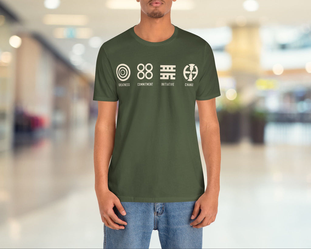 Person wearing a green t-shirt with white graphics and text in a blurred indoor setting