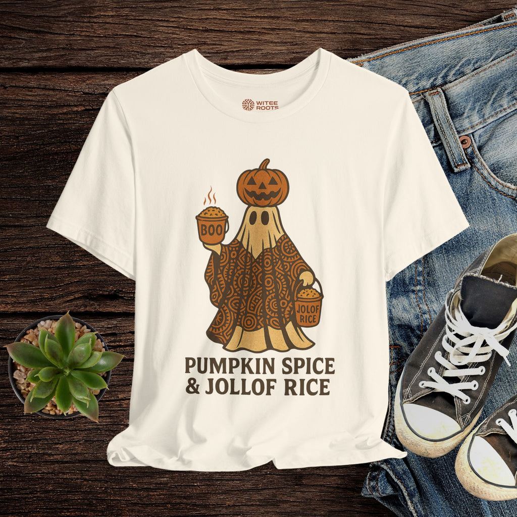 Beige t-shirt with a graphic design of a ghost holding a pumpkin and a bowl, with text 'Pumpkin Spice & Jollof Rice', displayed on a wooden surface with jeans and sneakers.