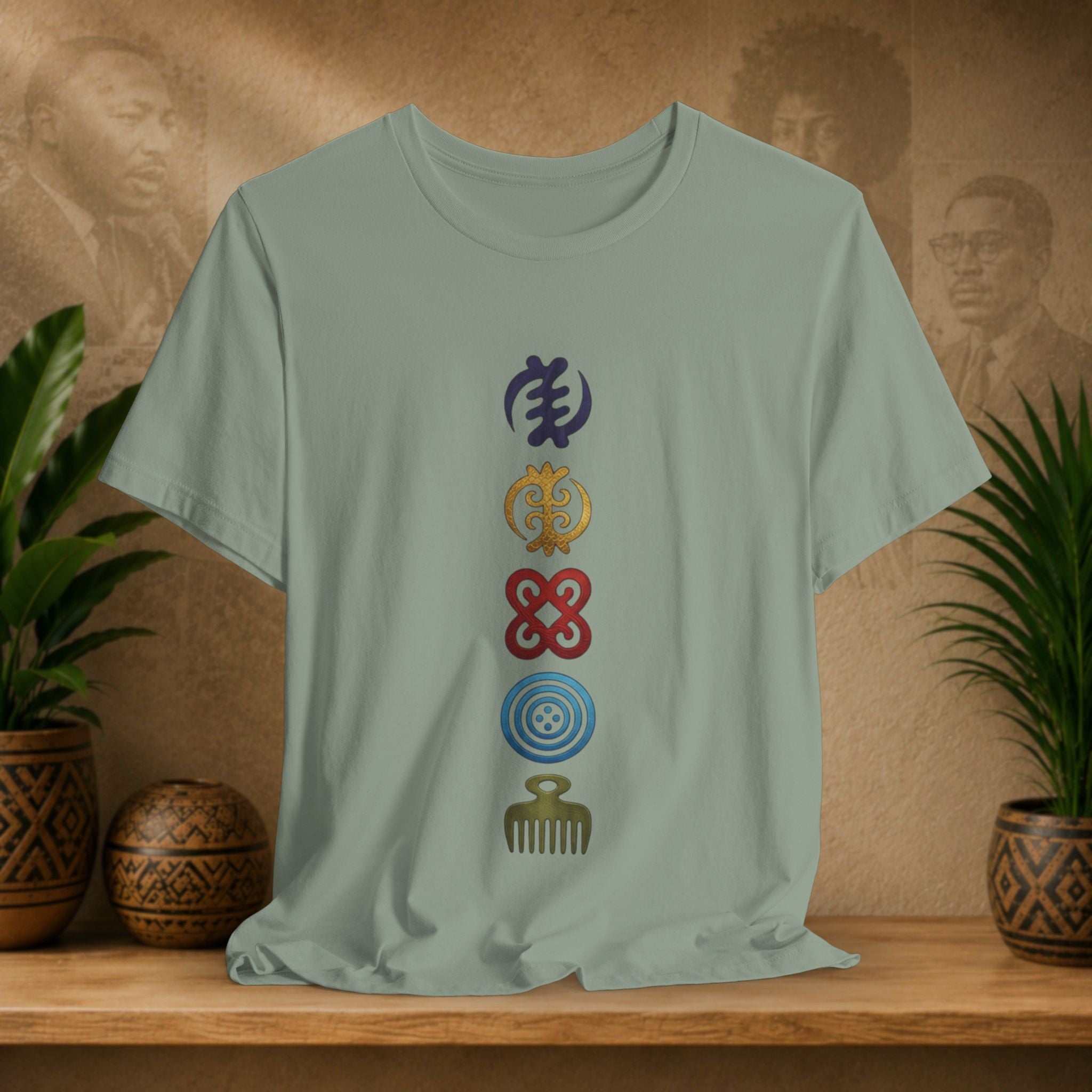 Light green t-shirt with colorful symbols on a wooden shelf with decorative items and plants.